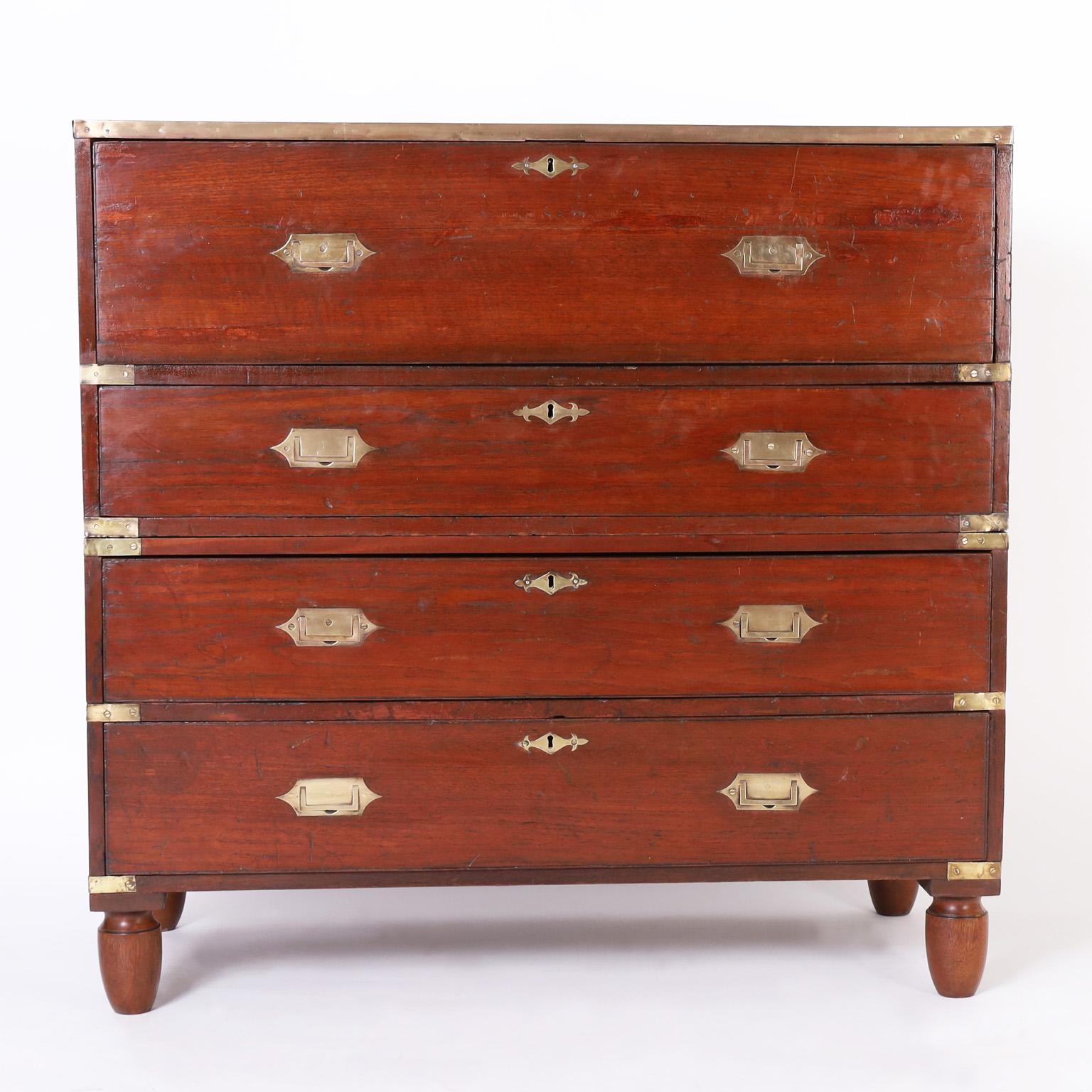 Handsome 19th century British Colonial Campaign chest handcrafted in mahogany featuring a pullout desk in the top with drawers and niches, three storage drawers below, brass hardware, turned feet and plenty of experience.