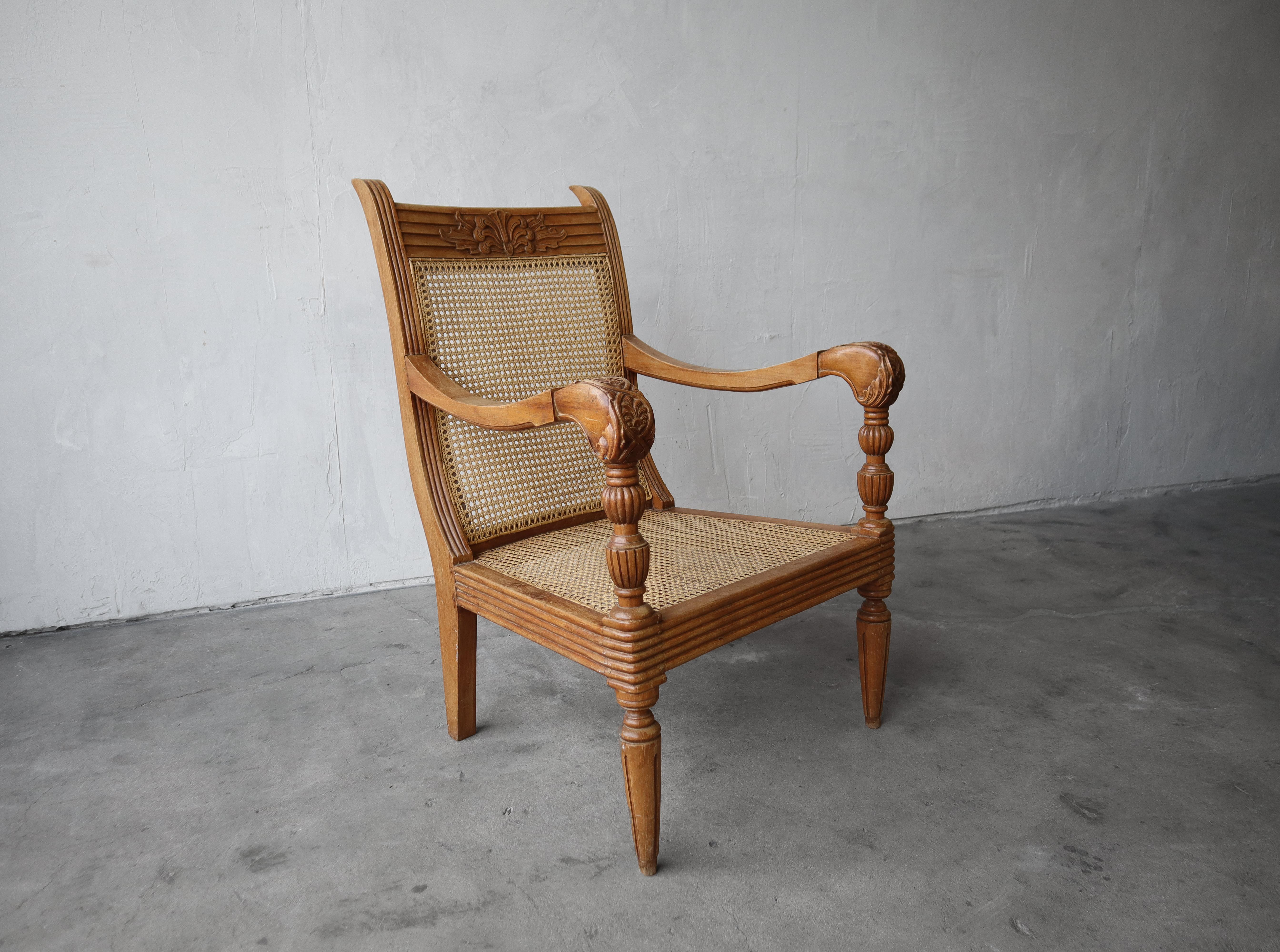 Beautiful antique carved teak and cane lounge chair. The beauty is truly in the details of this chair. The carved and turned wood are stunning. It's in excellent condition for its age. There is some light patina from age and use, mainly on the arms,