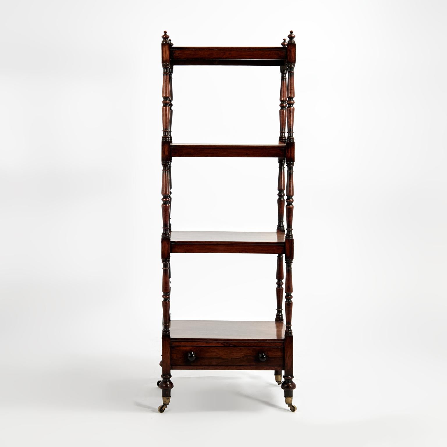 Stand inglese del XIX secolo realizzato a mano in legno di palissandro con una forma elegante a quattro livelli con terminali torniti su supporti torniti, un cassetto nella cassa inferiore e rotelle in ottone. 