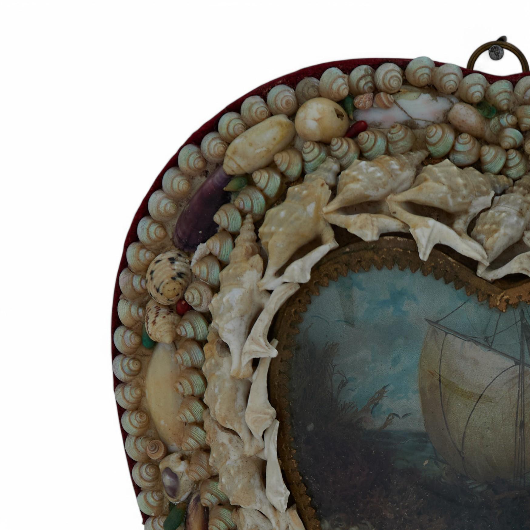 Charming 19th Century English heart form sailors valentine ambitiously handcrafted with exotic seashells around a sailboat image as seen through a glass lens. 