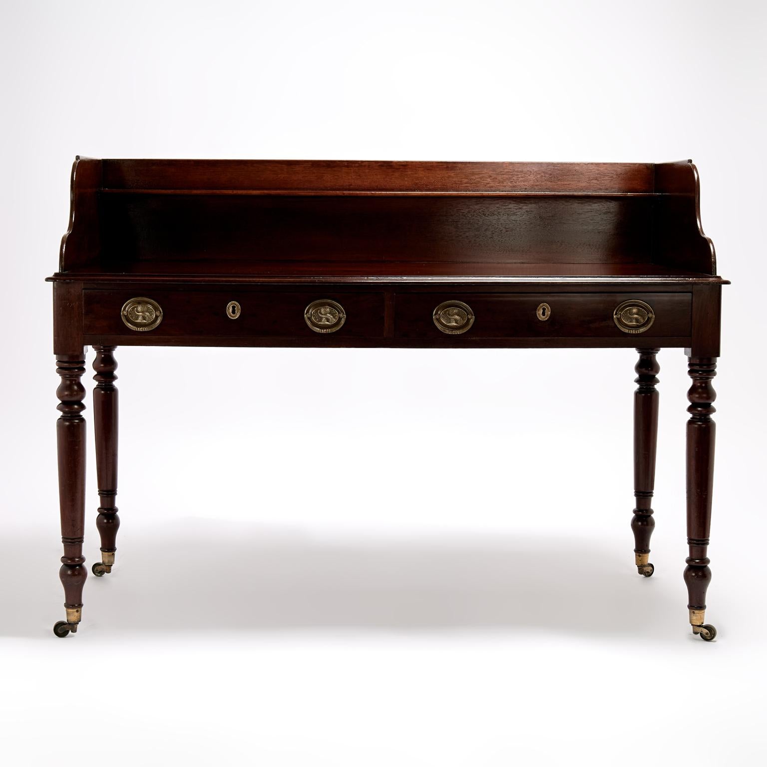 Handsome 19th Century British Colonial server handcrafted in mahogany featuring a dramatic gallery with shelf on a case with three drawers having brass hardware on classic turned legs. French polished in the traditional old world manner. 