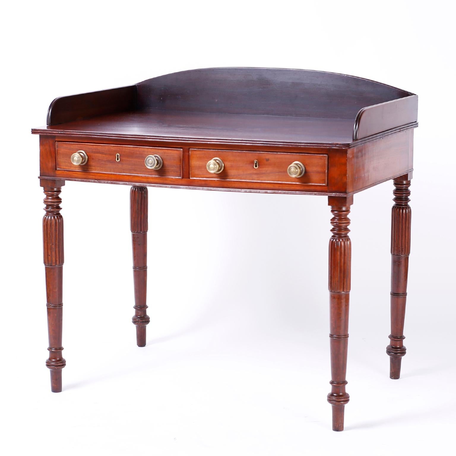 British colonial server or bar with a rosewood top and gallery with beaded edges over a mahogany base with two drawers having cast brass hardware set on elegant turned and carved legs.
