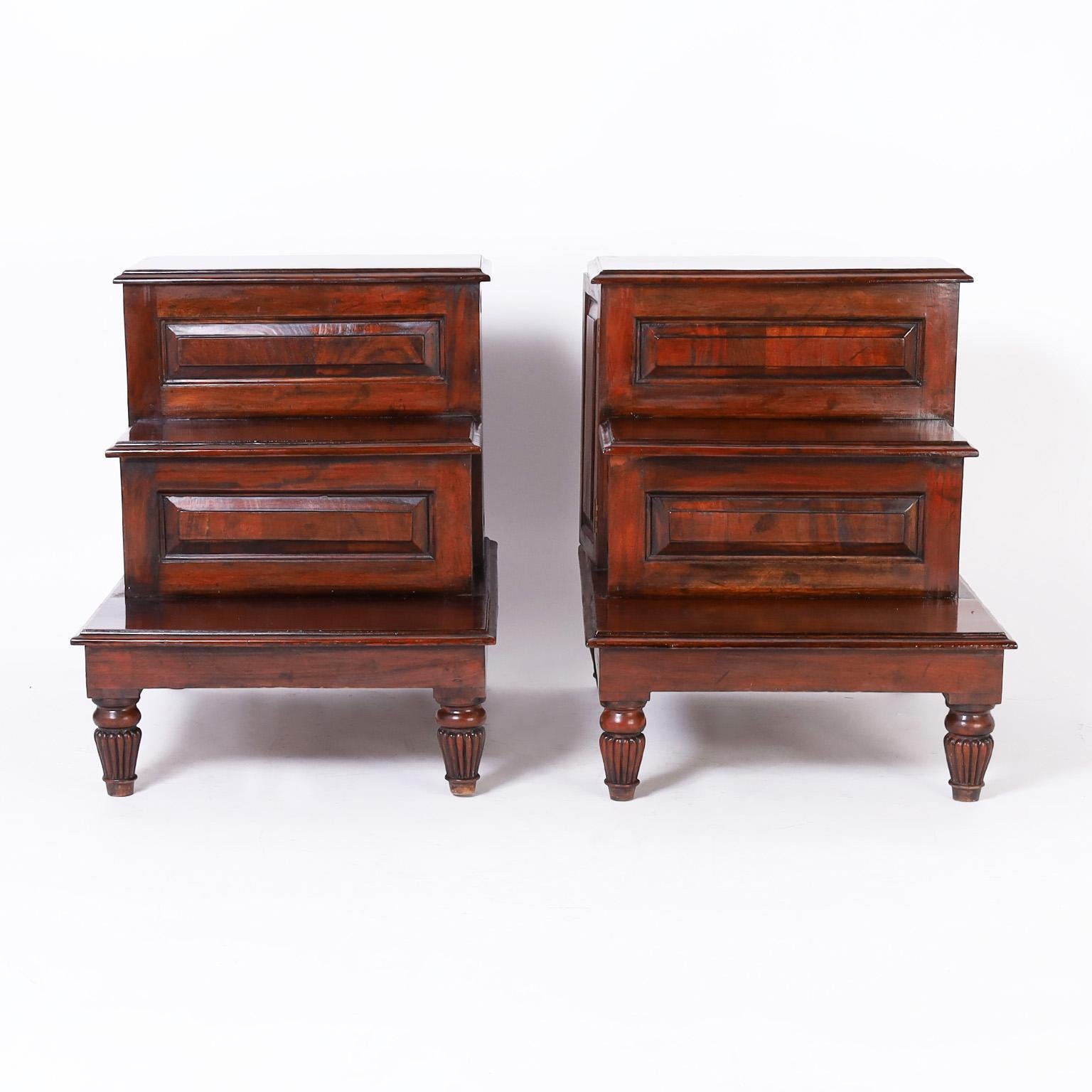 Rare pair of 19th century English stands or tables crafted in mahogany featuring a step down form with paneled sides, hidden storage and turned and fluted legs.