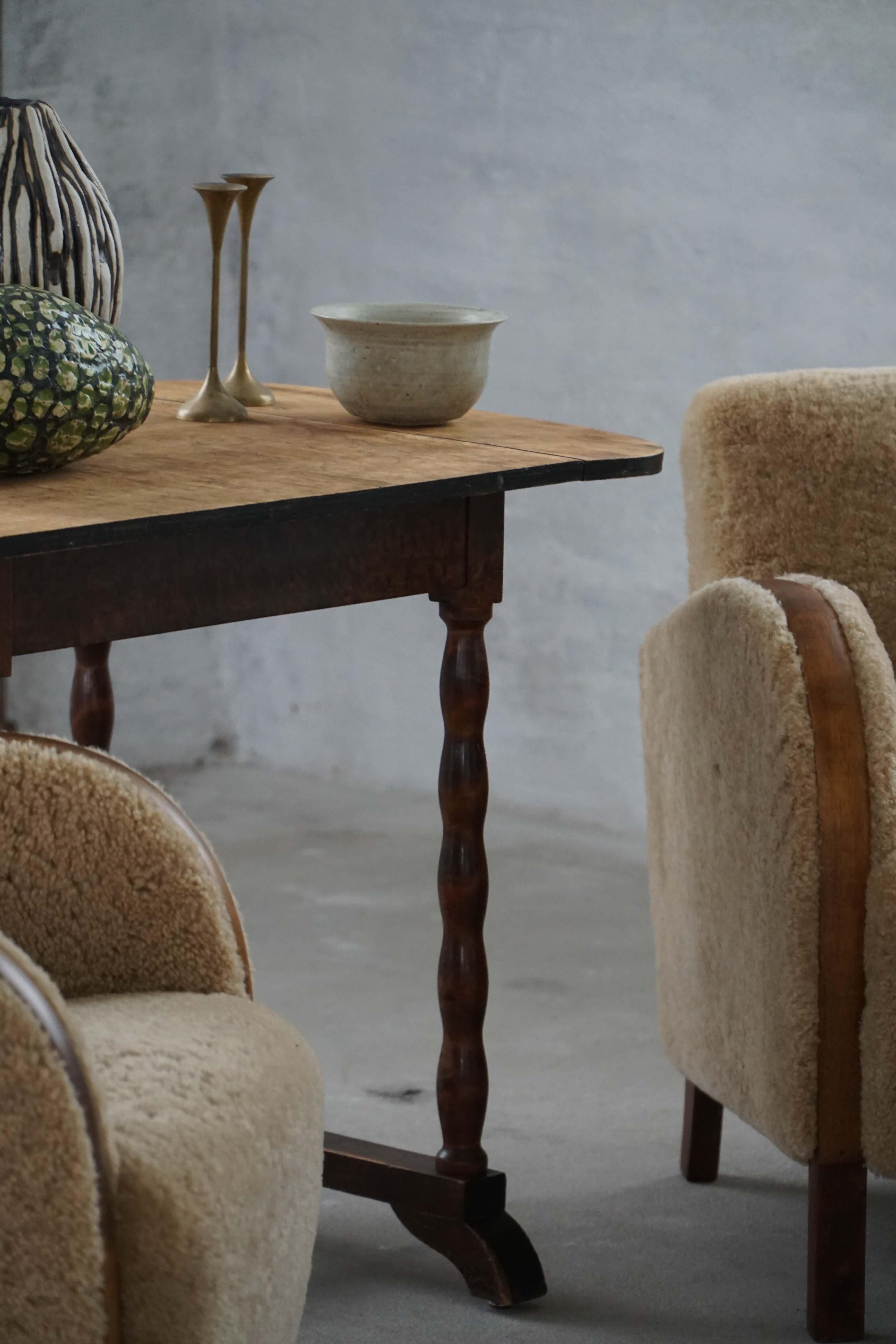 This charming British desk/side table showcases a refined simplicity and craftsmanship rooted in early 20th-century Edwardian design. Made from oak and birch, the table features beautifully turned legs and a base that balances decorative detail with