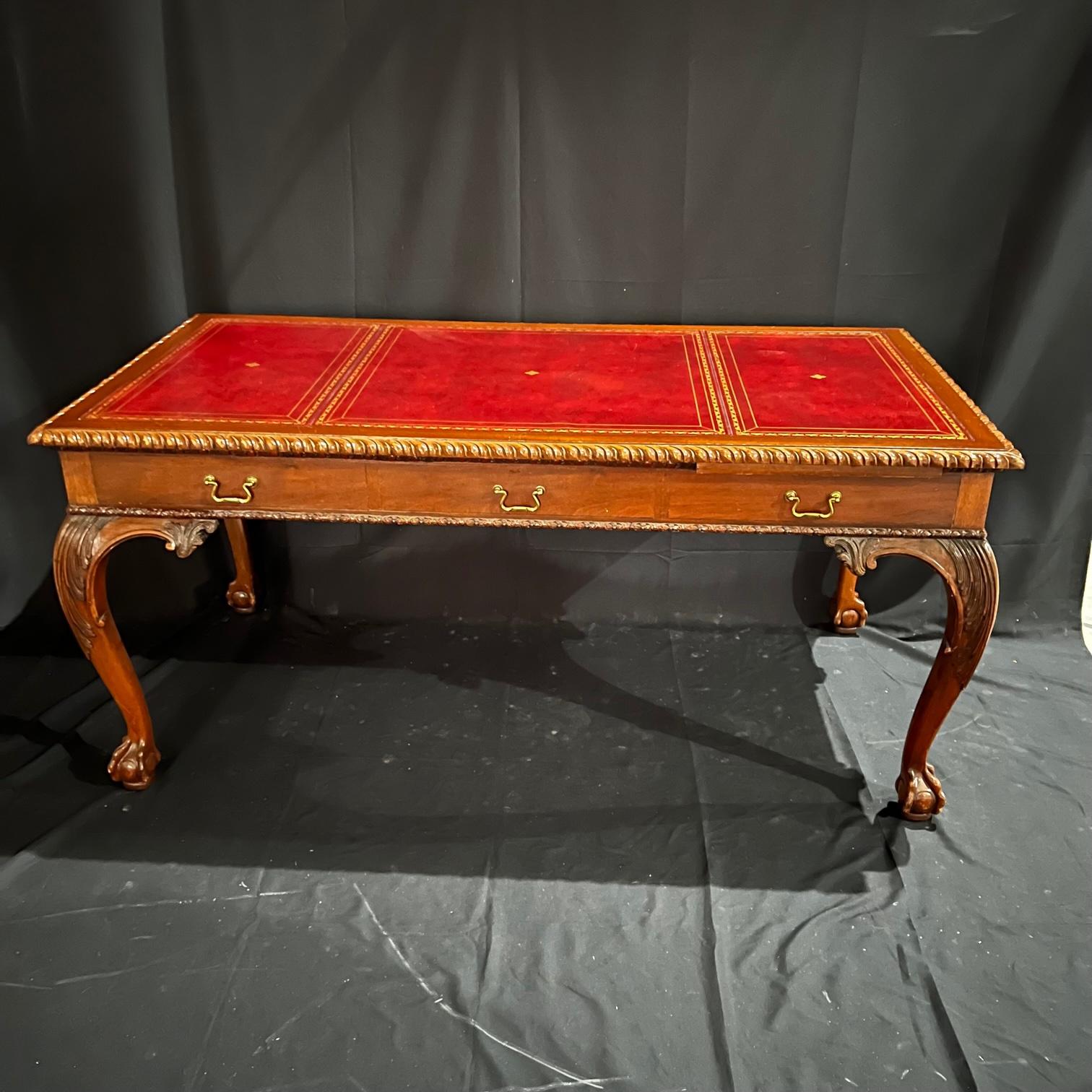 Lovely classic rectangular mahogany desk with claw & ball feet, cabriole shaped legs, beautiful carvings and long leaf extensions on the side and back. The decoration along the waist, upper part of the legs and on the edges of the upper board in the