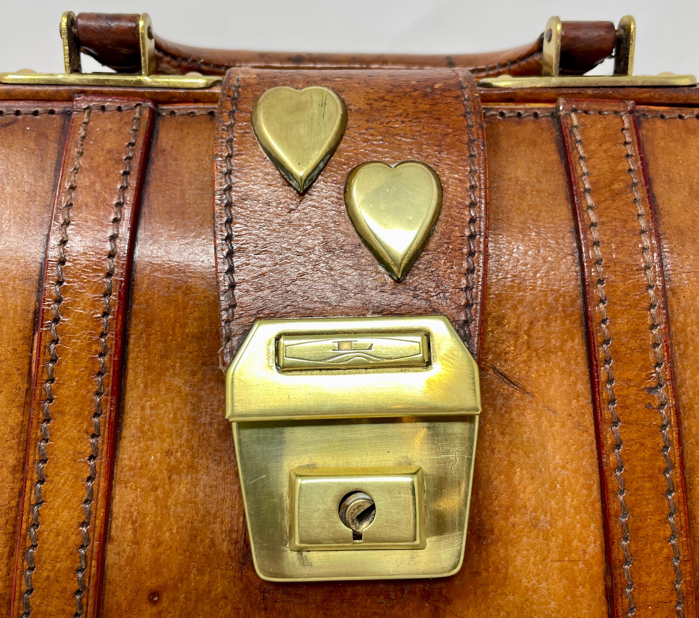 Antique British military leather satchel bag with 2 brass hearts, circa 1900. The hearts specifically associate with love of country.