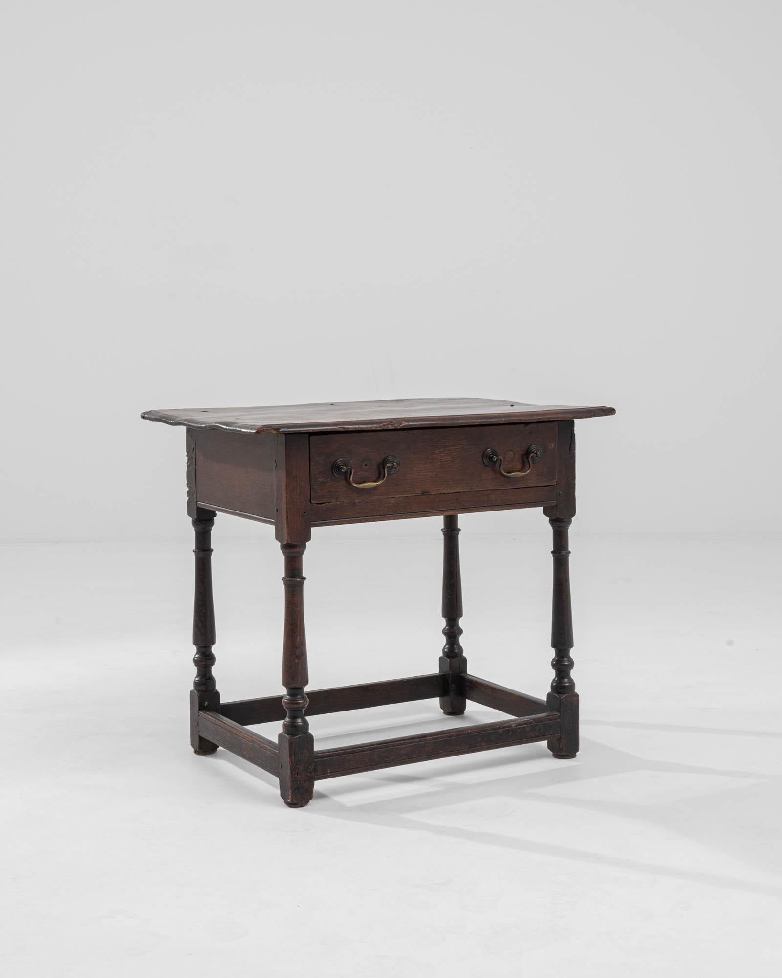 An oak table made in the 19th century United Kingdom. The gently organic shape of this table’s top contrasts in compelling fashion with the ornately lathed legs and tidy construction that undergirds it. The rich and warm brown wood emits an aura of