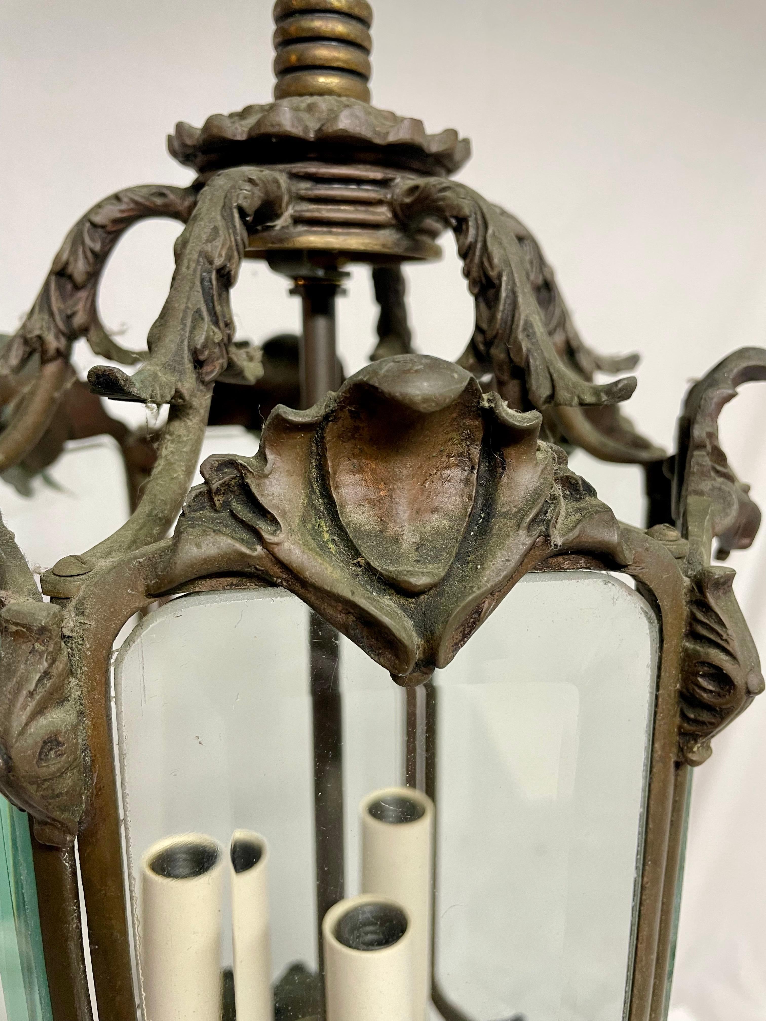 Bronzo antico  E ciondolo in ottone con sei mani  Pannelli di vetro smussato. Sembra che in origine utilizzasse il gas, ma è stata convertita per utilizzare tre lampadine a candelabro. In condizioni generali molto buone per l'età. Il fondo è