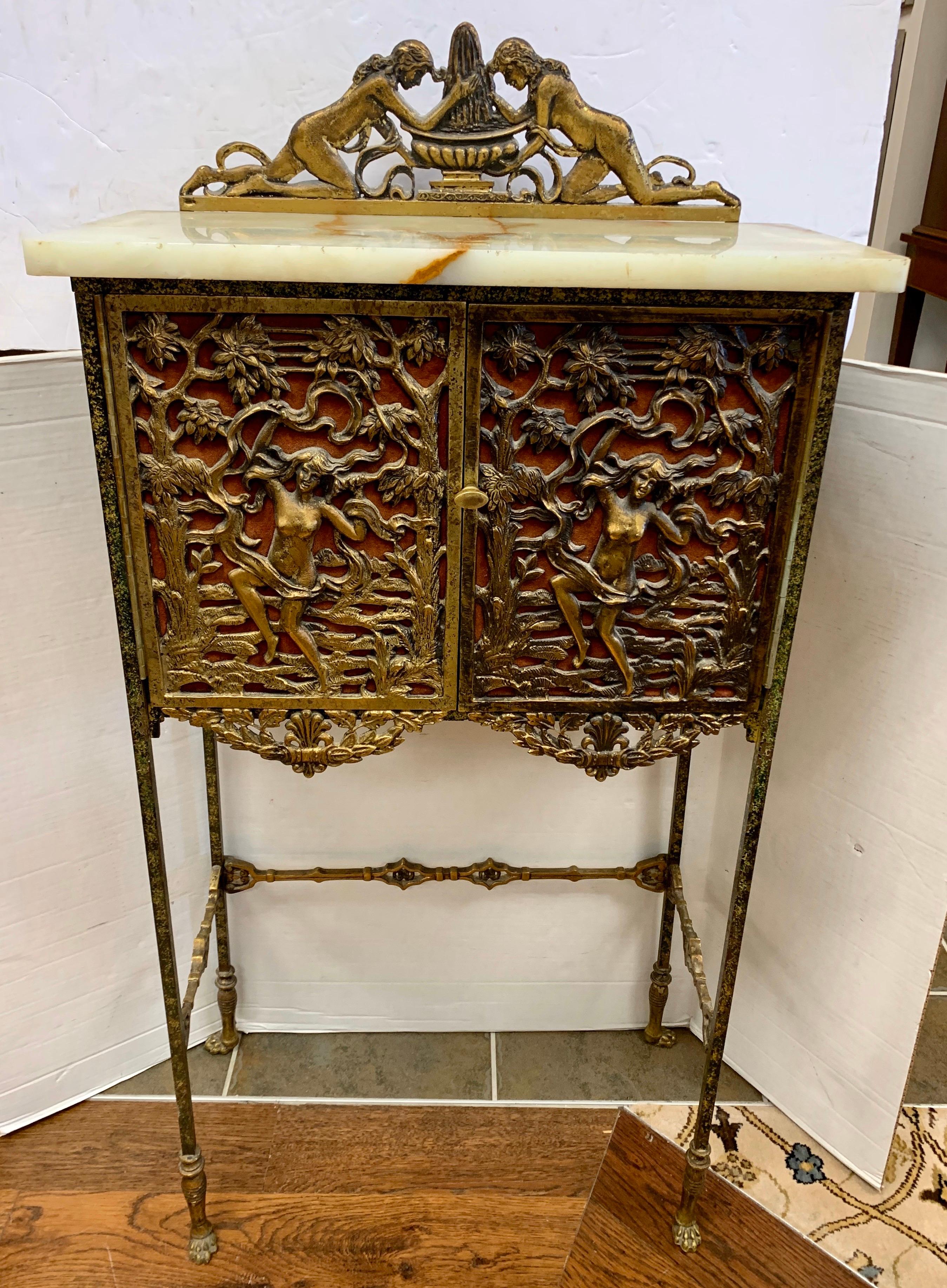 Figural bronze and iron onyx telephone stand table attributed to Oscar Bach. Features ornate bronze figures of women on the two front doors and on the sides; bronze paw feet, and onyx top. Use it as a bar or console. A unique antique piece.