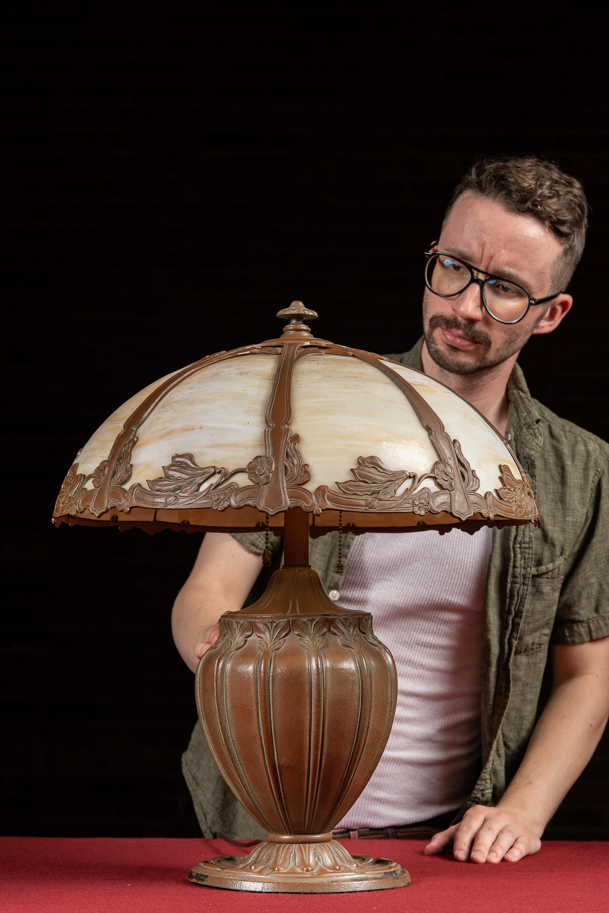 c. 1920s; Pittsburgh Lamp, Brass & Glass Co. - Pittsburgh, PA

Caramel slag glass table lamp with ornate cast spelter base and floral Art Nouveau overlay.

This early electric lamp was produced during the golden age of decorative lighting by