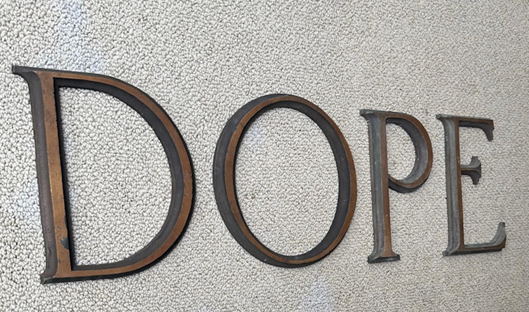 4 antique bronze letters from a sign or building in England dating to the late 19th century. Raised relief with gold accents that have muted over time. All in very fine shape with no cracks, chips or breaks. They measure 8 3/8
