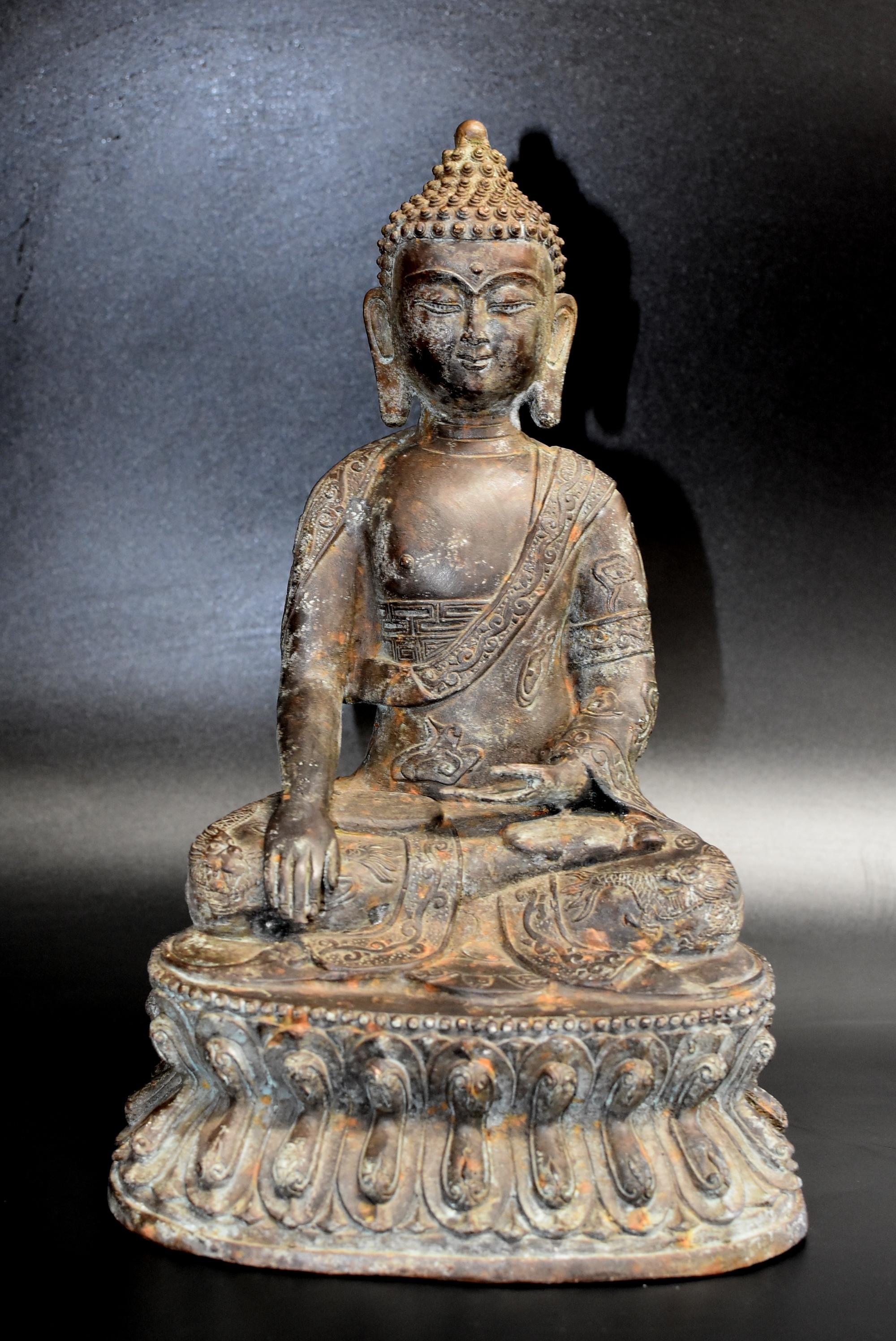 Exceptional value! A beautiful, large bronze statue of a Buddha. Buddha is seated on a lotus throne and is wearing an elaborately decorated robe with motifs of clouds, dragons, foliage and scrolls. A Tang dynasty style full face, refined facial