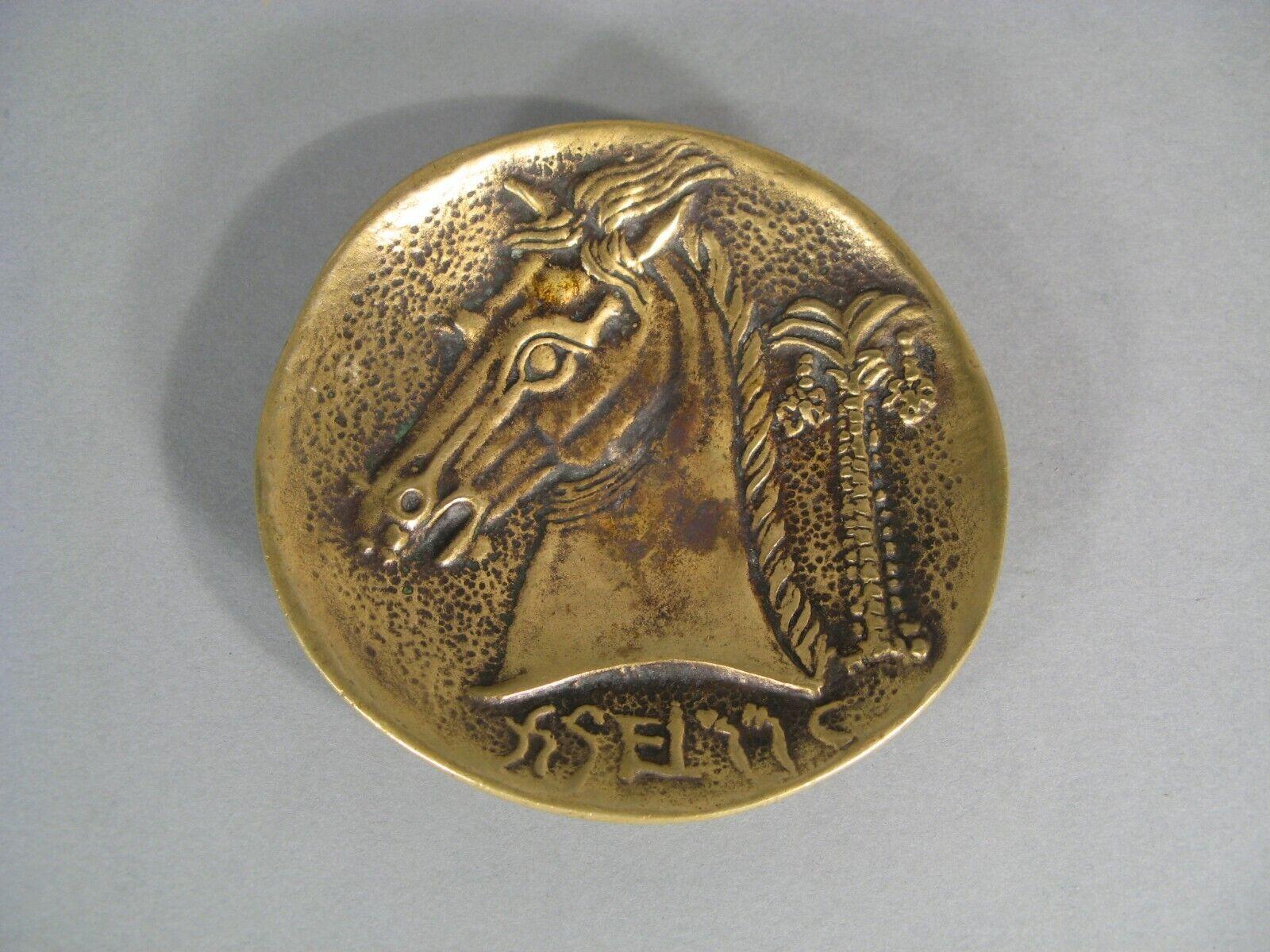 This antique catchall, crafted in patinated bronze, showcases an Art Deco design featuring a horse's head and a palm tree.

Style: Art Deco
Material: Patinated bronze
Design: Horse's head and palm tree motif
Signature: Marked 