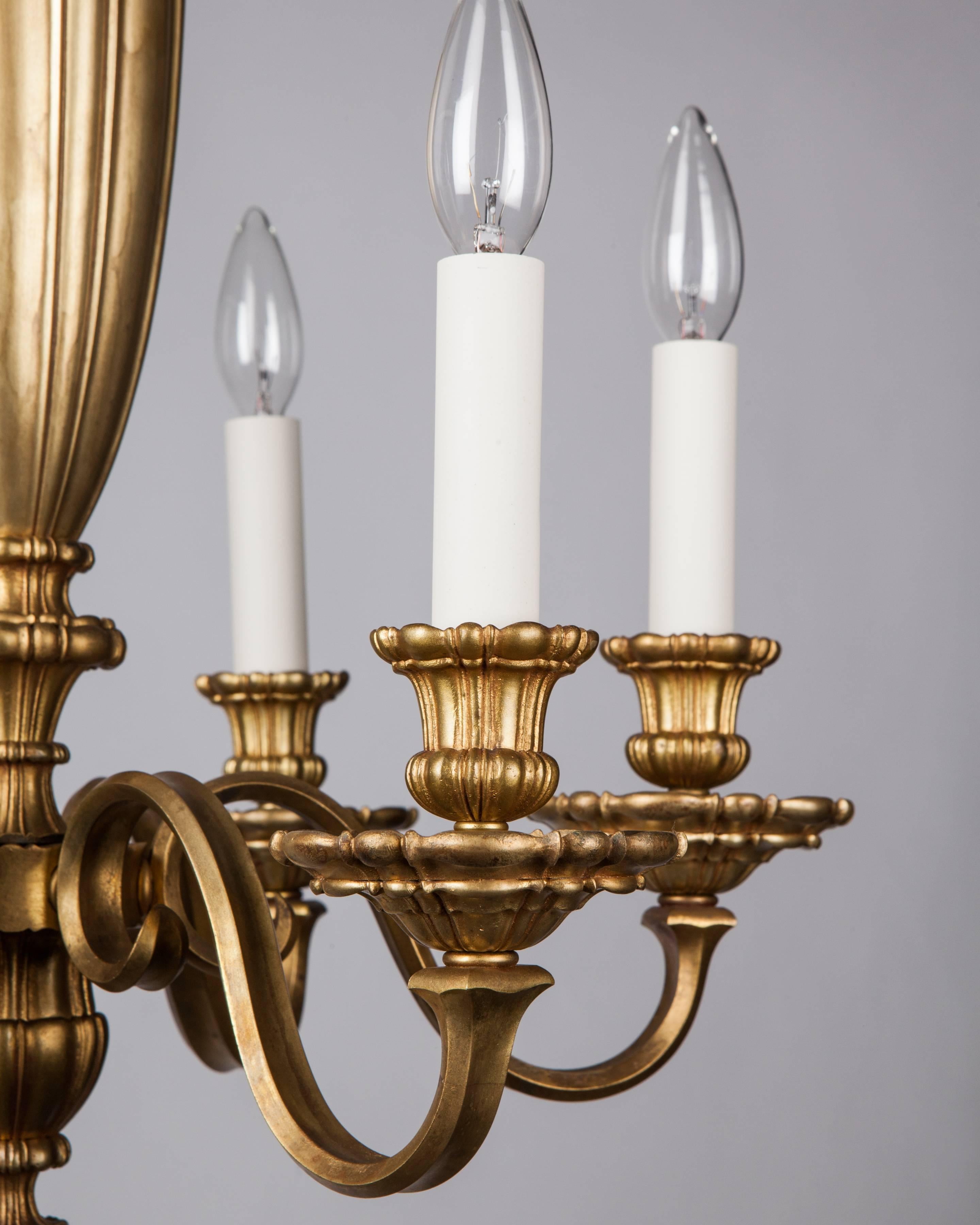 AHL4110
An antique six-light chandelier with linenfold details shared by the canopy, cups, waxpans and vasiform body. In a darkened brass finish retaining some of its original gilding. Attributed to the Boston maker Pettingell Andrews