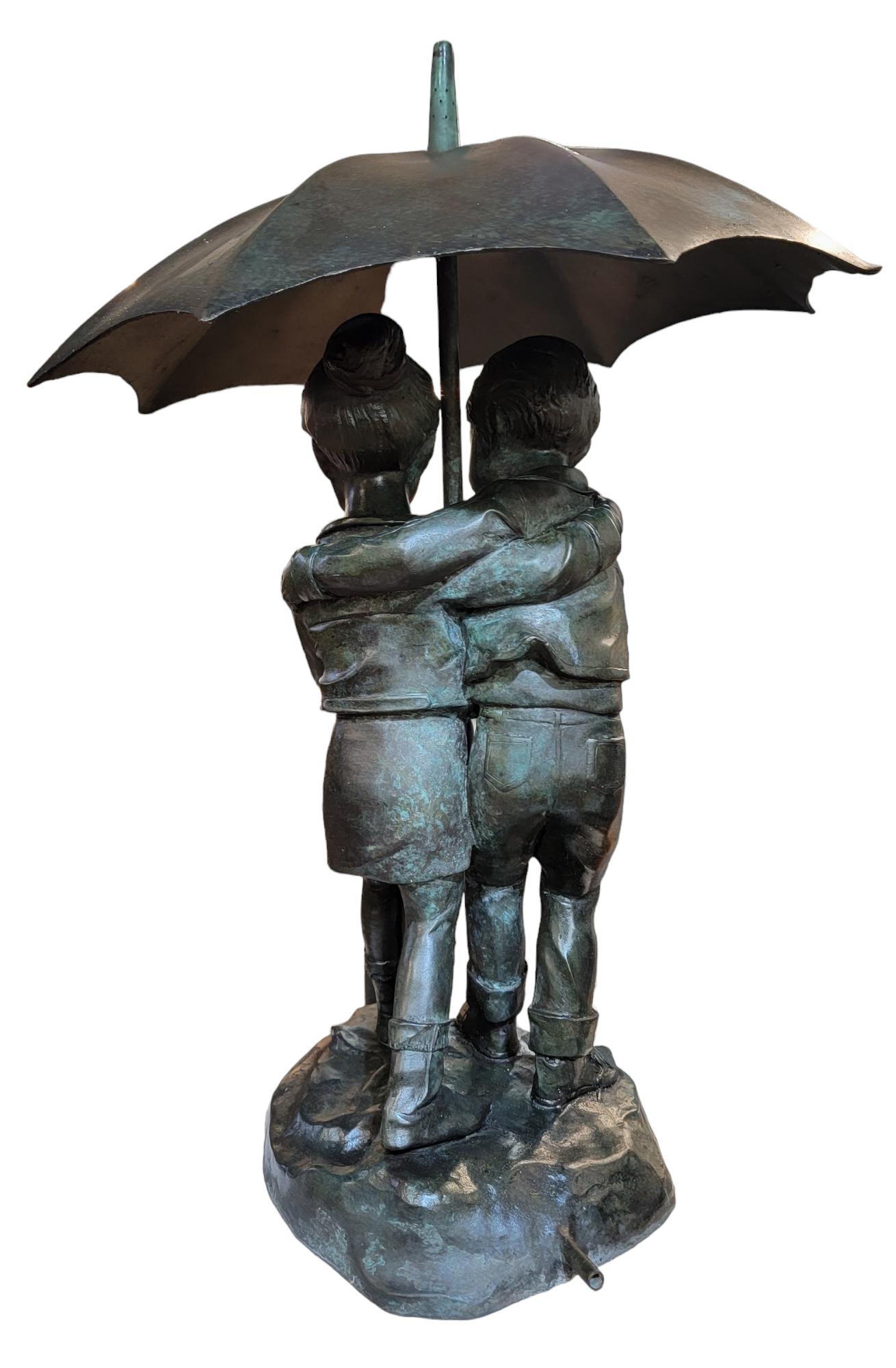 Fontaine de jardin pour enfants avec parapluie en bronze antique signée. Garçon et fille tenant un parapluie qui les protège de l'eau qui descend. Il s'agit d'une fontaine/statue amusante. Le site  Le parapluie est amovible.  - 20h x 12 diamètre
