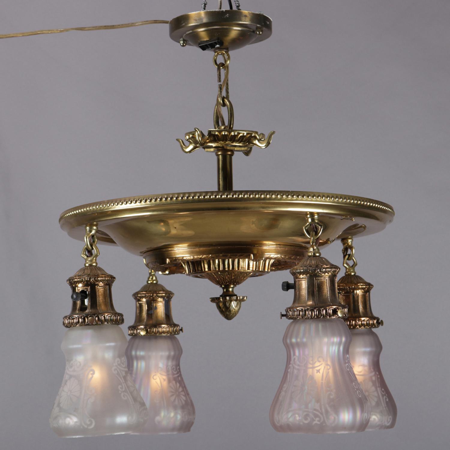Antique bronze chandelier features flush mount circular and stepped cast base having foliate motif and central drop finial with 4 drop lights terminating in opalescent shades with stencil etched foliate decoration, circa 1920

Measures: 20