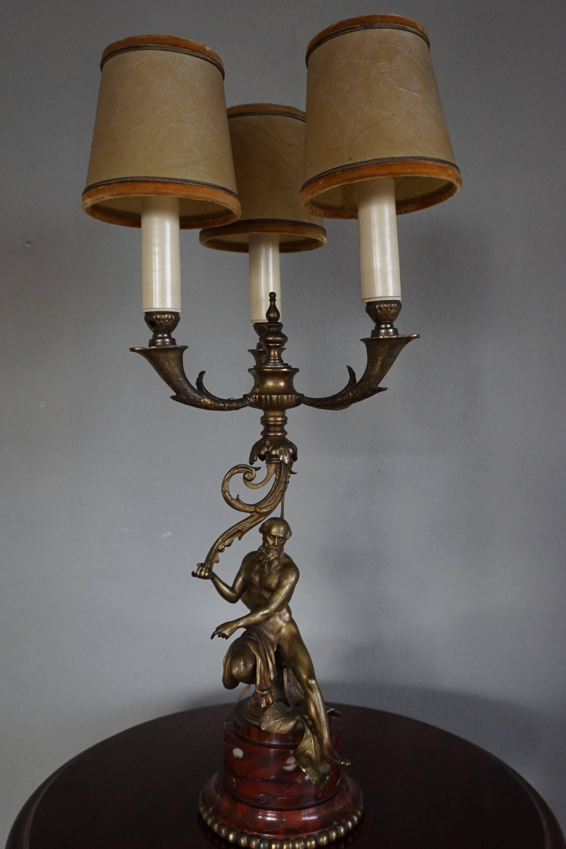 Lampe de table en bronze, unique en son genre et très élégante.

Dans la mythologie grecque, Zeus est surtout connu comme le maître du ciel et de la terre et comme le père de tous les dieux et de l'humanité. Dans cette lampe de table ancienne et de