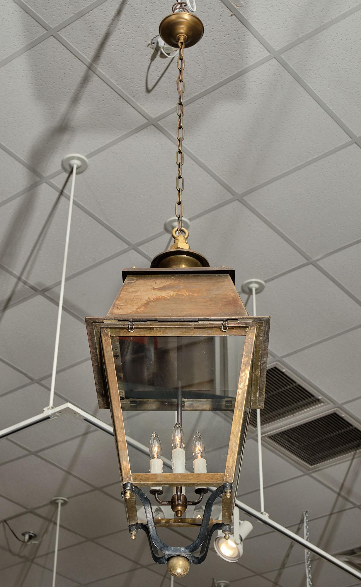 Antique bronze French lantern with clear glass held in place by a bronze and steel structure. It has been newly wired to fit US standards.