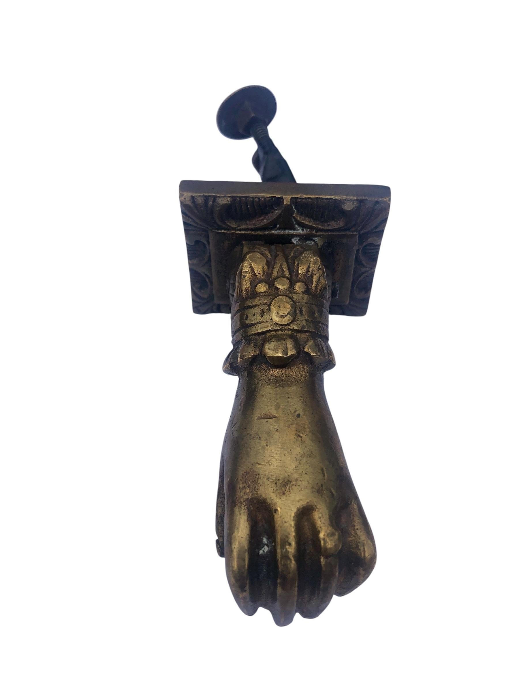 Aldaba manual de bronce antiguo con la placa de cierre y los pernos.