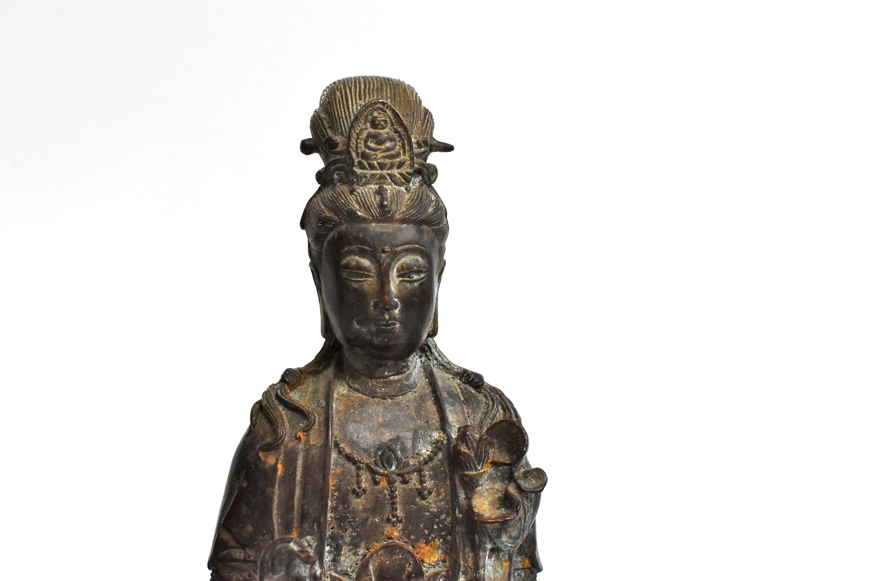 A wonderful old piece of bronze sculpture featuring the Chinese Goddess of Compassion Kwan Yin. She sits on an recumbent elephant and holds a willow branch. Her right hand shows the motion to flicking blessing water from the willow. Kwan Yin's face