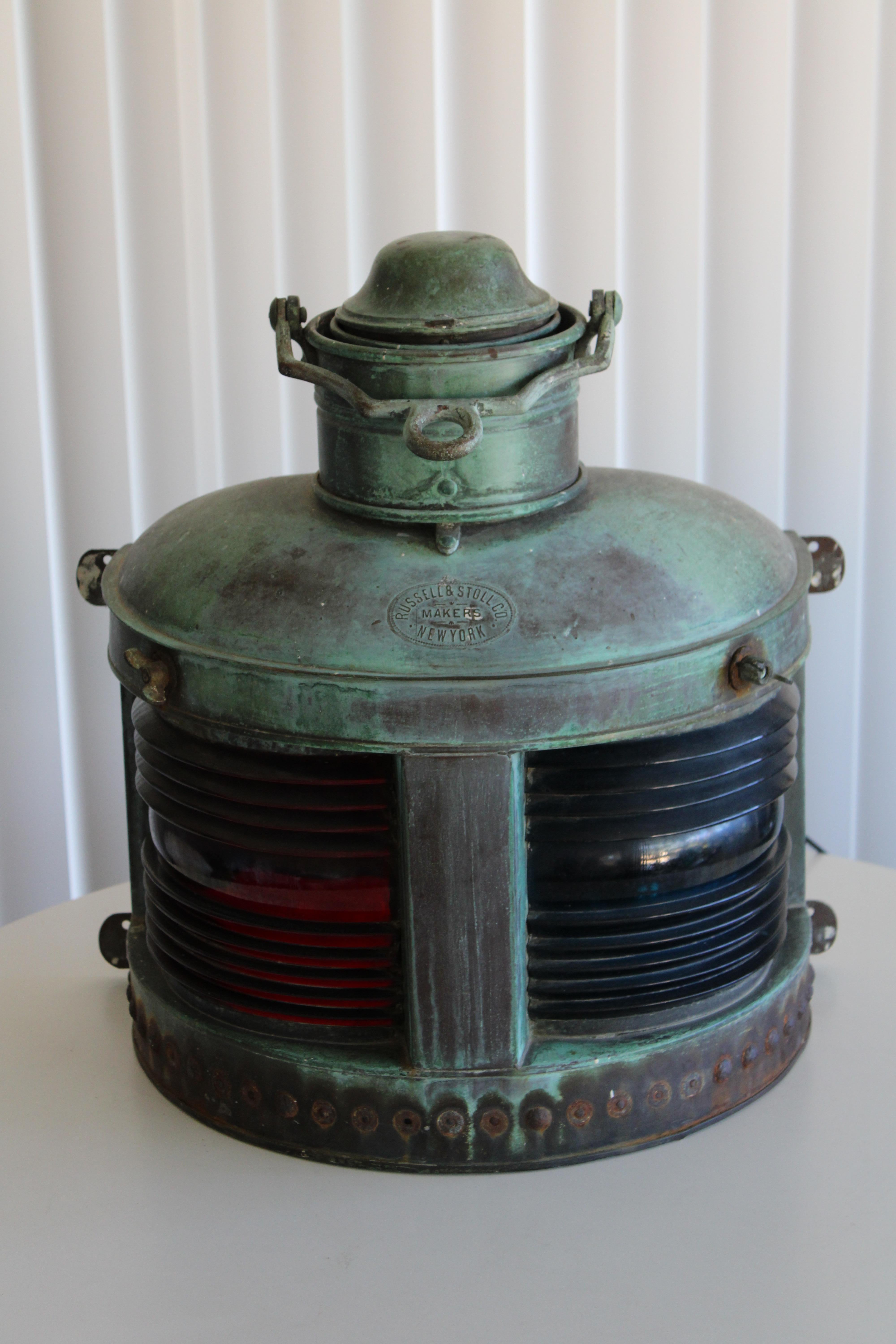A heavy solid bronze ship's light with thick red and blue-green prism glass lenses. Heavily patinated bronze. 19th century lantern was originally a kerosene lamp. Recently rewired for electrical use. Marked RUSSEL & STOLL MAKERS NEW YORK. Measures