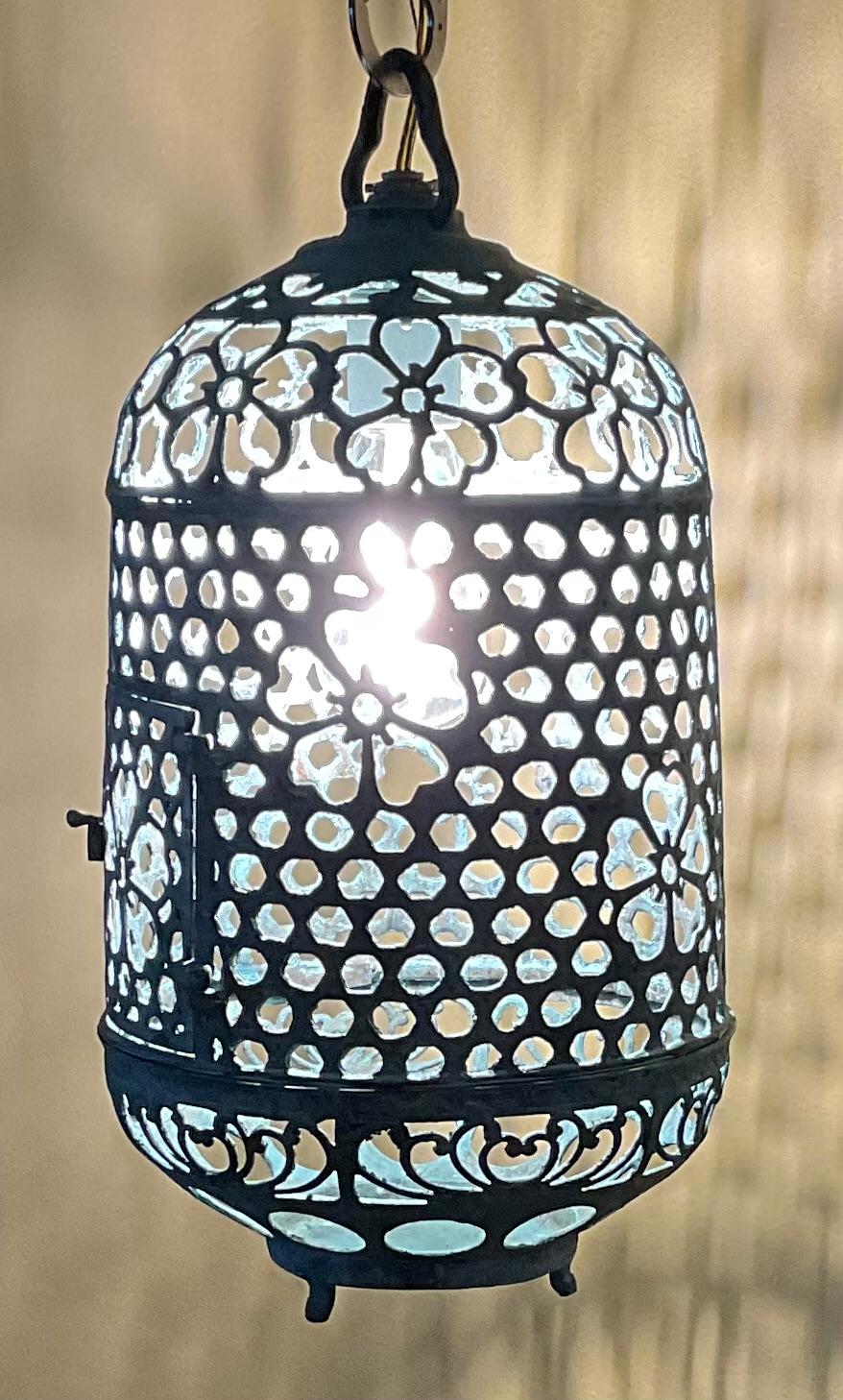 Este exquisito farol antiguo es un verdadero testimonio de artesanía y tiempo. Fabricada en bronce o latón, ha desarrollado una rica pátina verde a lo largo de los años, lo que le añade un encanto único. Los intrincados motivos florales que adornan
