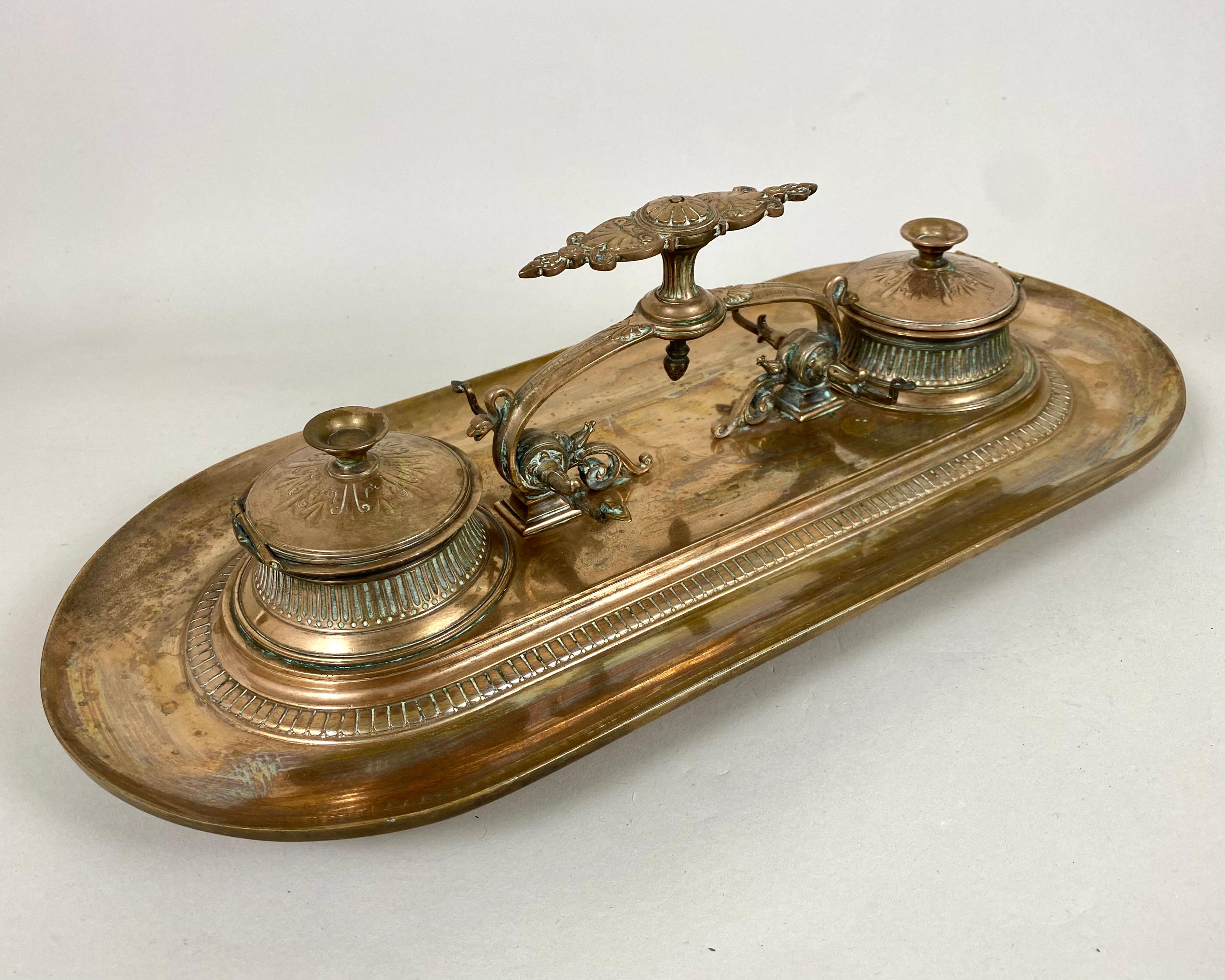 Double Bronze Inkwell Bronze Ink Stand with central handle and two pen holders flanked by lidded inkwells. Manufactured in France, 19th Century.

Made using traditional technology by casting bronze. Then polished to a shine. Will perfectly fit into