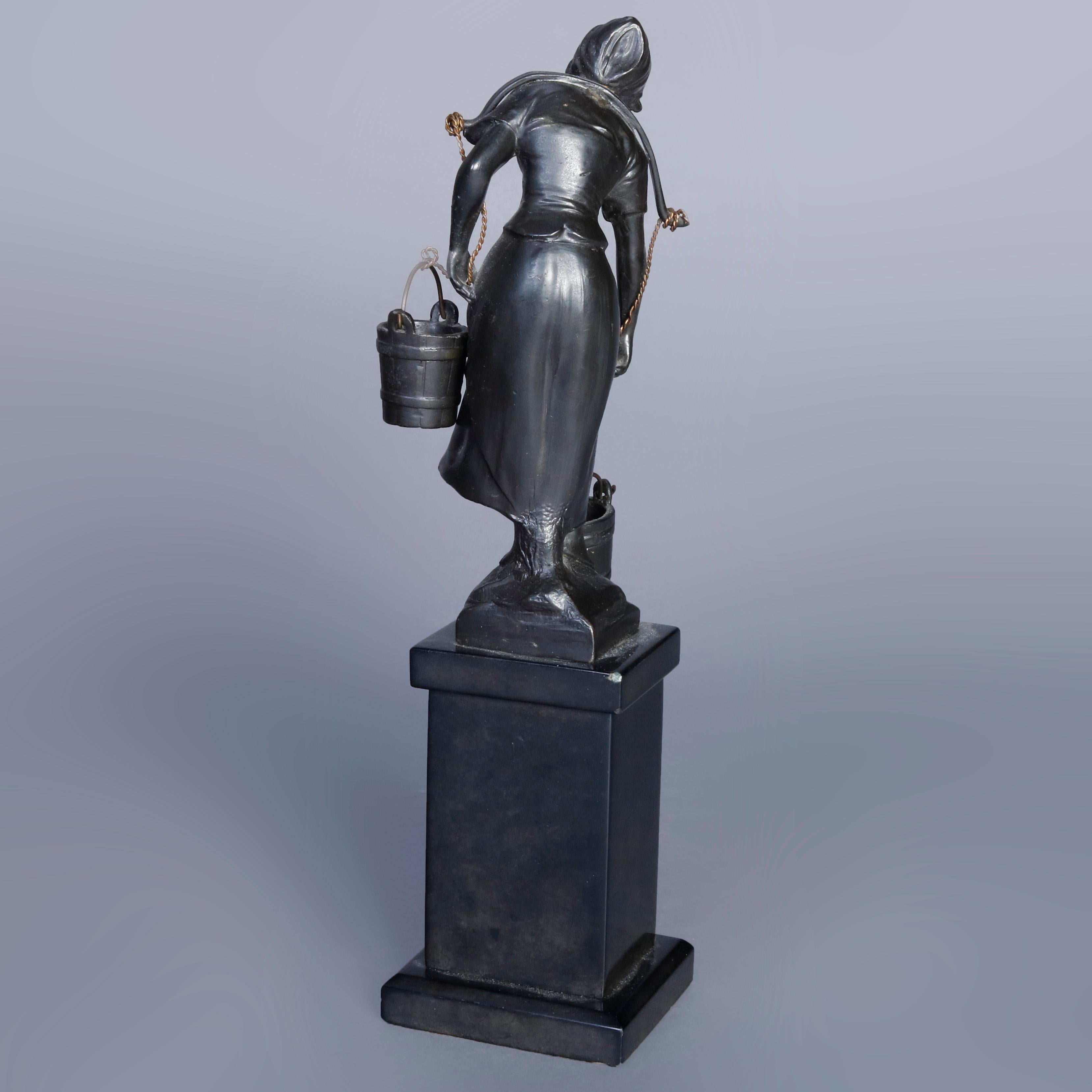 An antique cast bronze portrait sculpture depicts young woman carrying water buckets, seated on marble plinth, circa 1900

Measures- 10'' H x 3.25'' W x 2.75