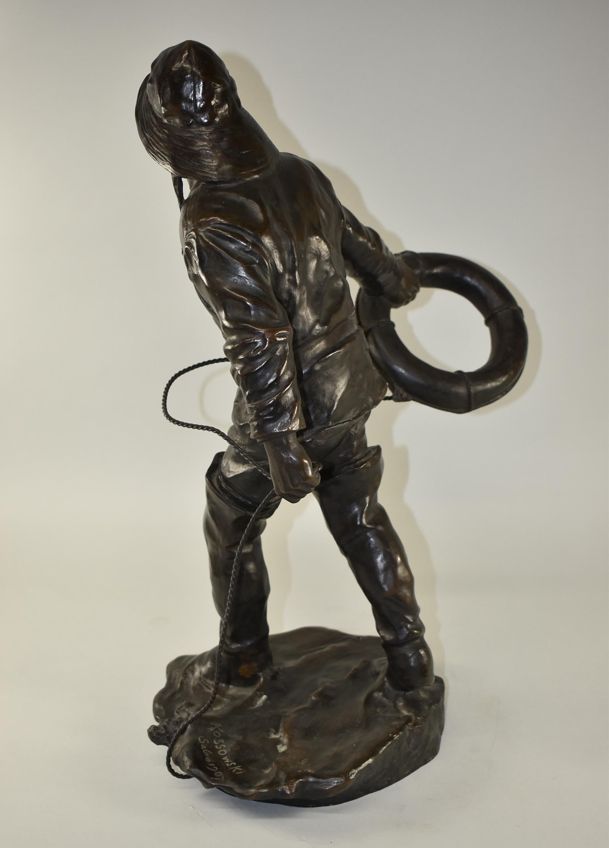 New England cast bronze sailor throwing a life preserver. Signed on the base Kossowski Salon dated 1907.