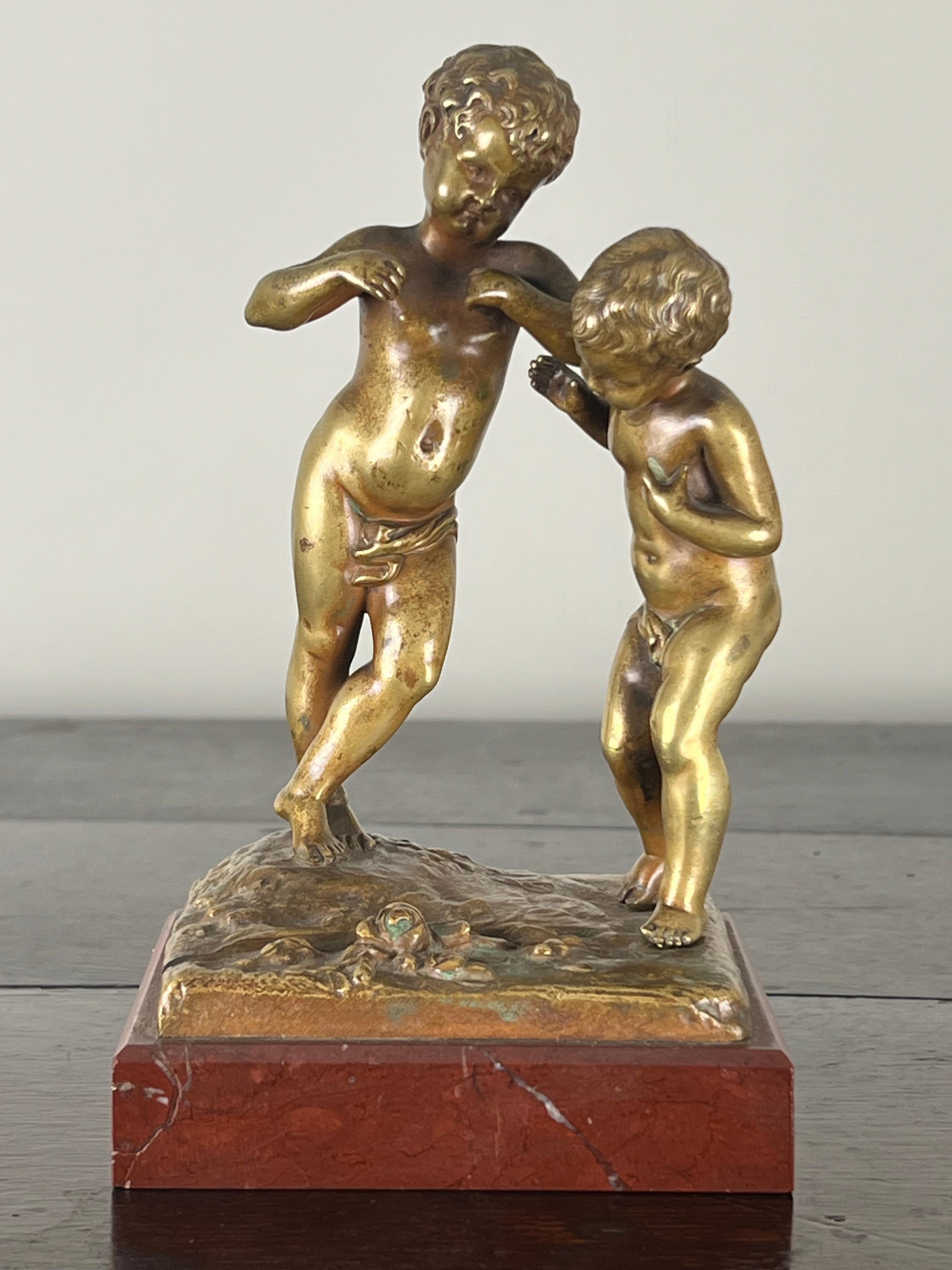 This Antique Bronze Sculpture “Jeunes Garçons” by the French artist Louis Kley (1833-1911) beautifully captures the innocence and playful nature of childhood. Depicting two young boys interacting in a tender moment, the sculpture exudes charm and