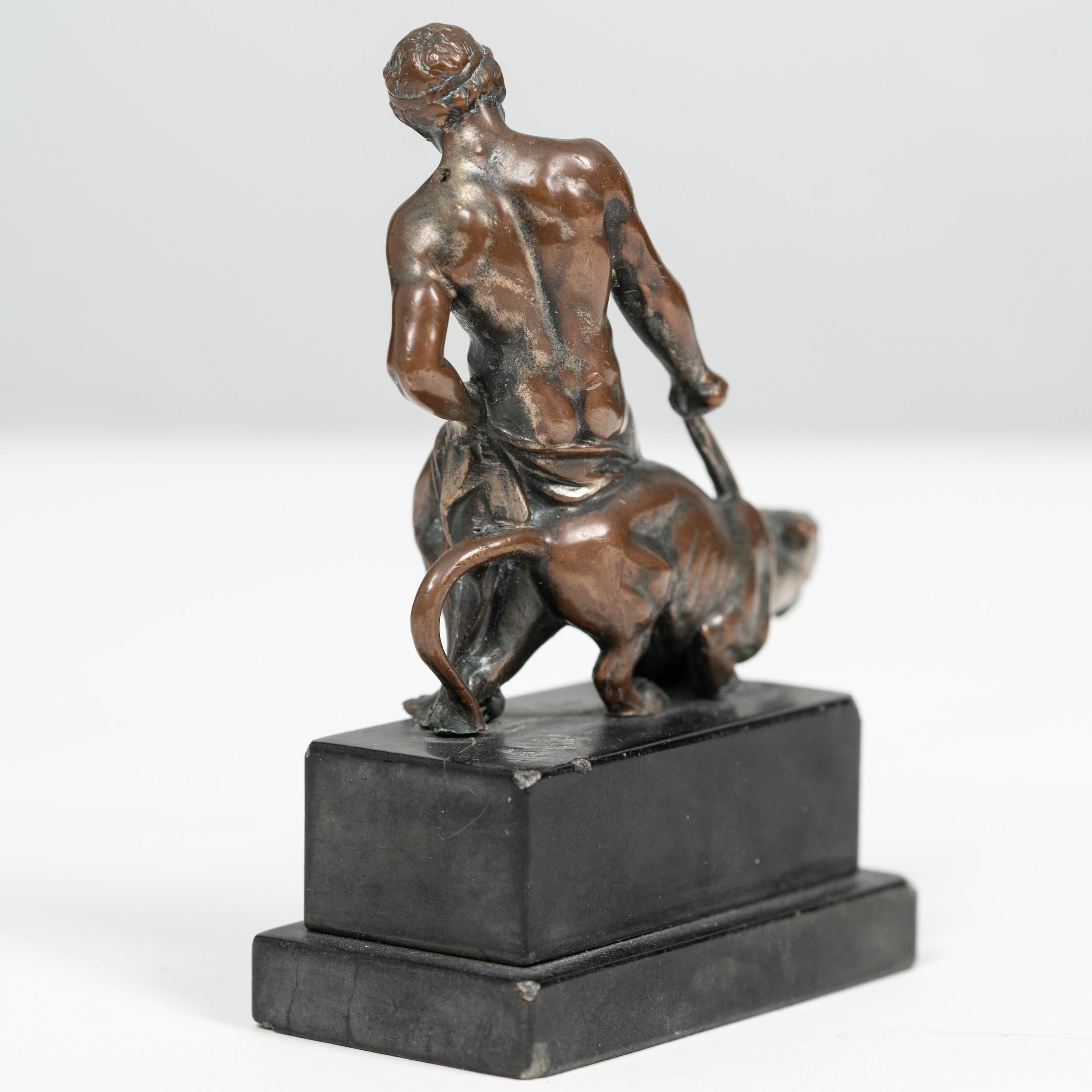Sculpture ancienne en bronze représentant un personnage masculin avec une panthère.