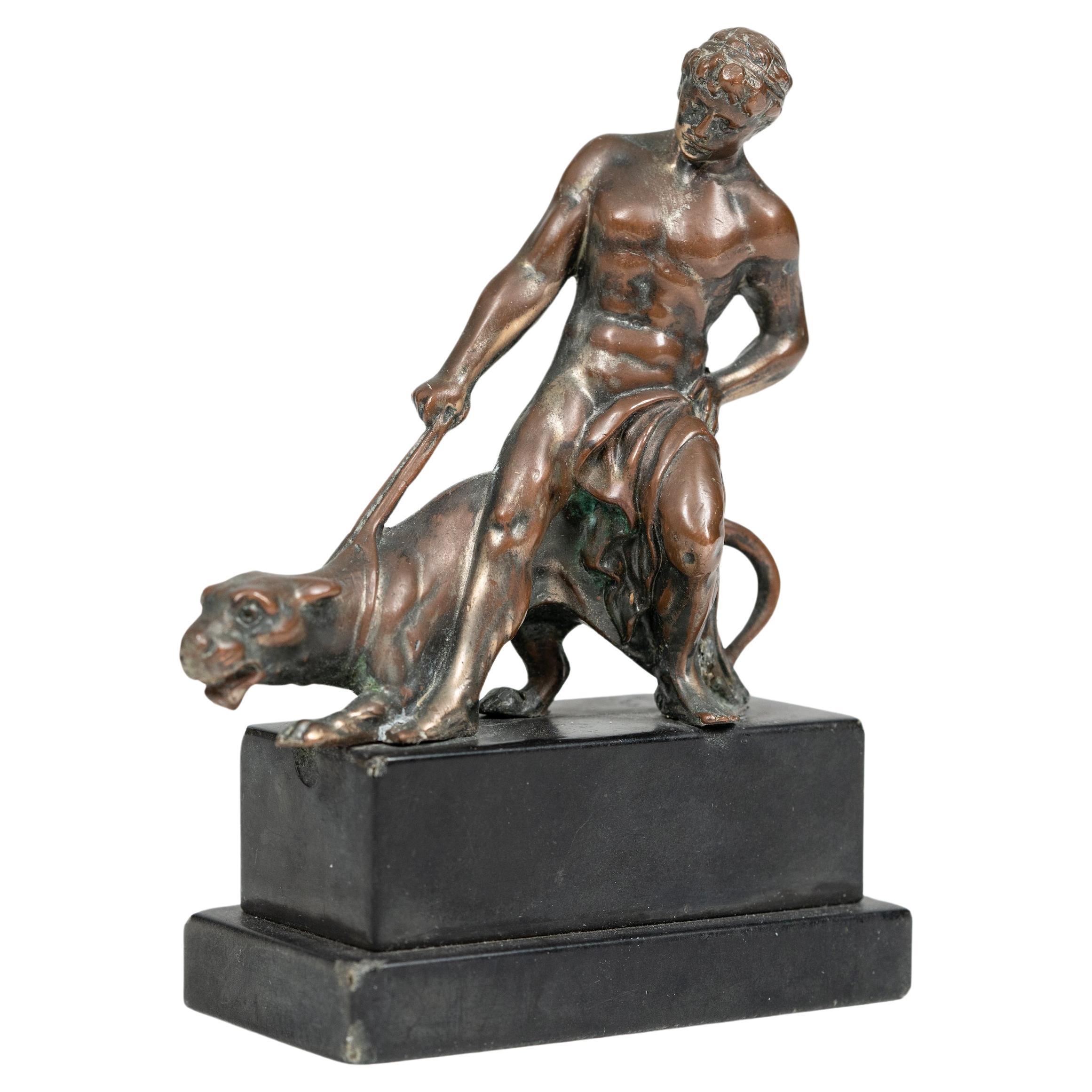 Sculpture en bronze antique d'un homme avec une panthère