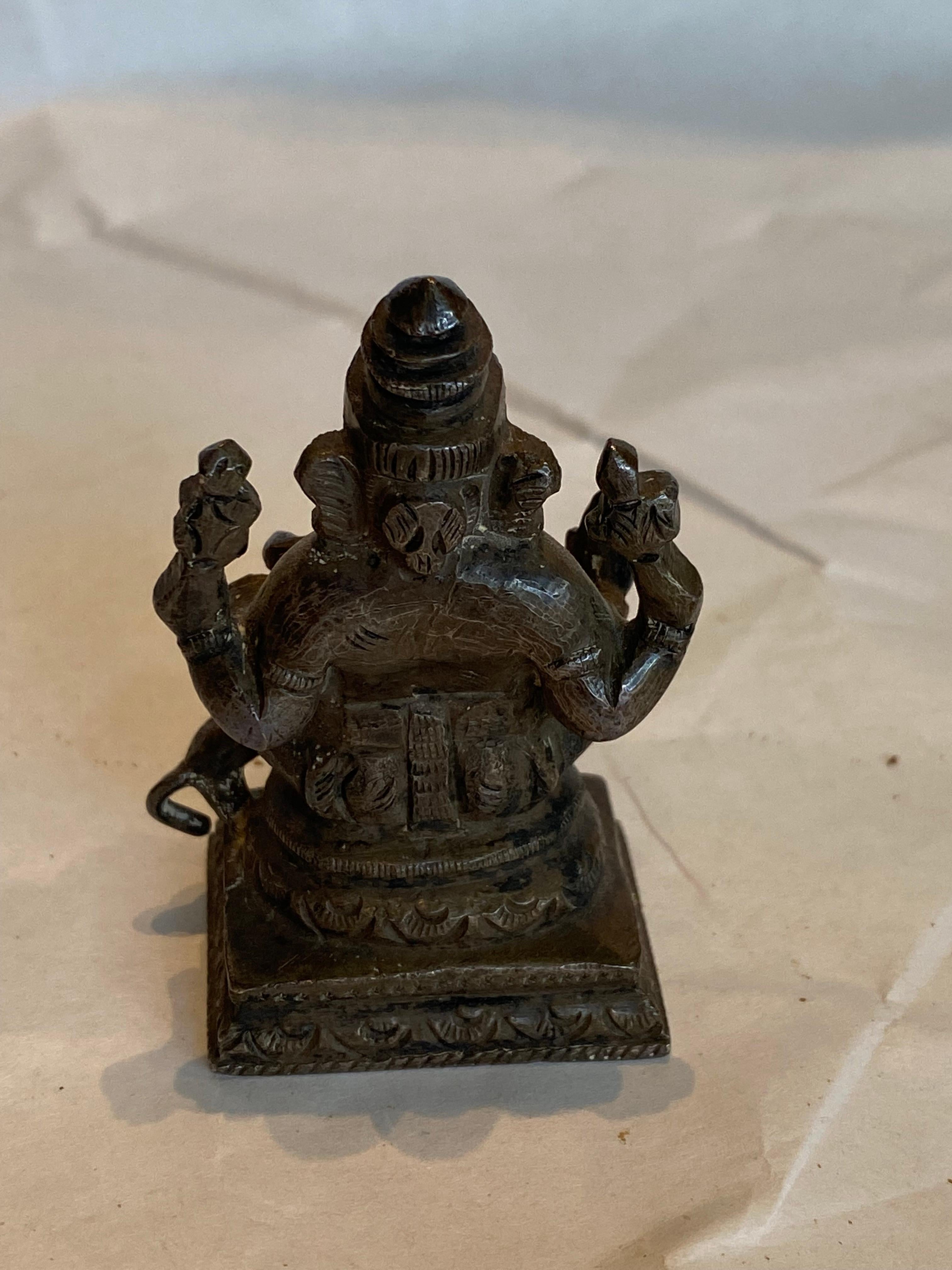 A wonderful keepsake of a bronze wax lost method of casting this Ganesha seated on a two step stand having a dog at its feet. The meaning of Ganesha this deity god is 