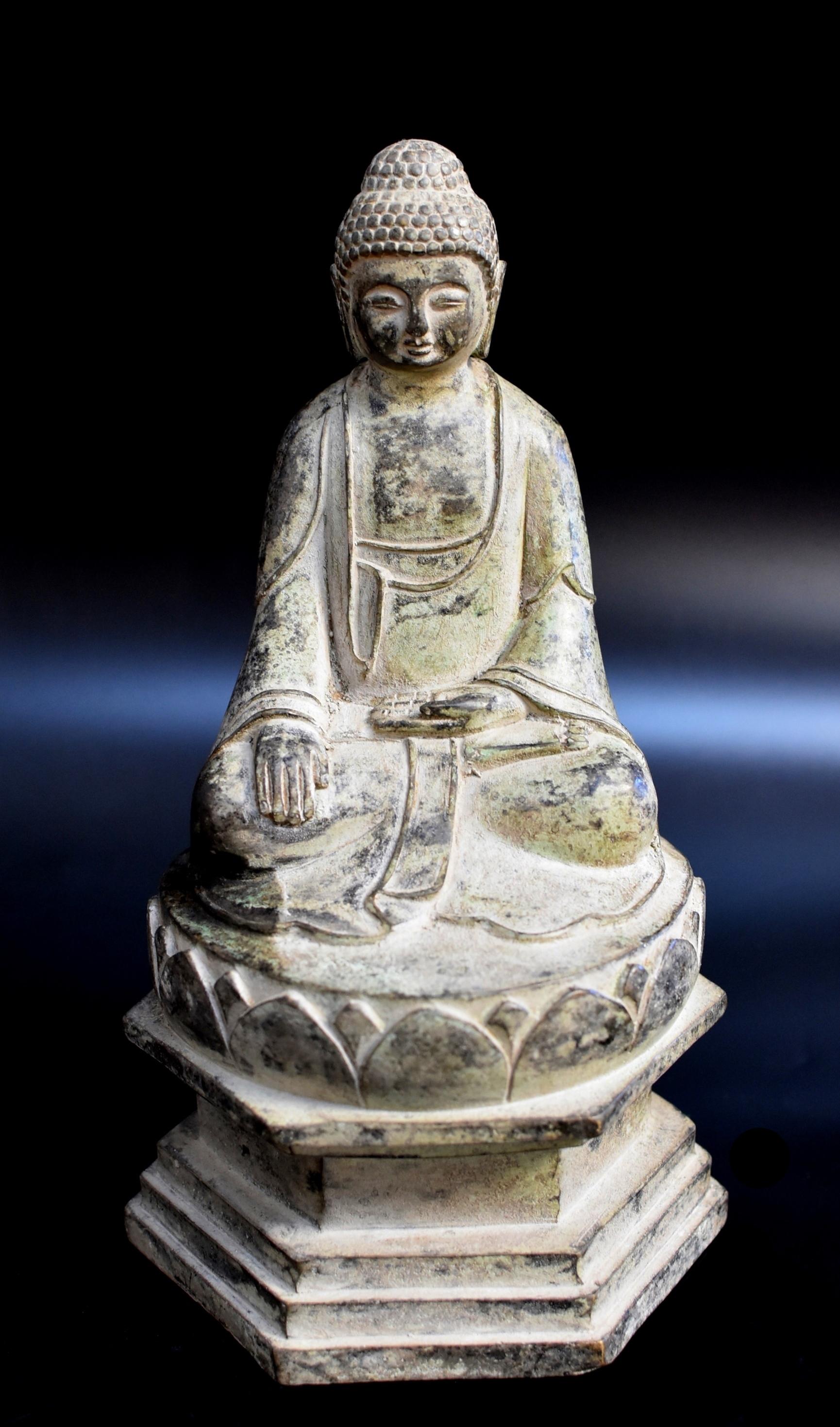 A beautiful bronze statue of Young Buddha. Seated in dhyanasana on lotus throne elevated on a high pagoda base, the right hand in bhumisparsha mudra and the left in dhyana mudra, wearing a flowing robe draping over the shoulders and pooling