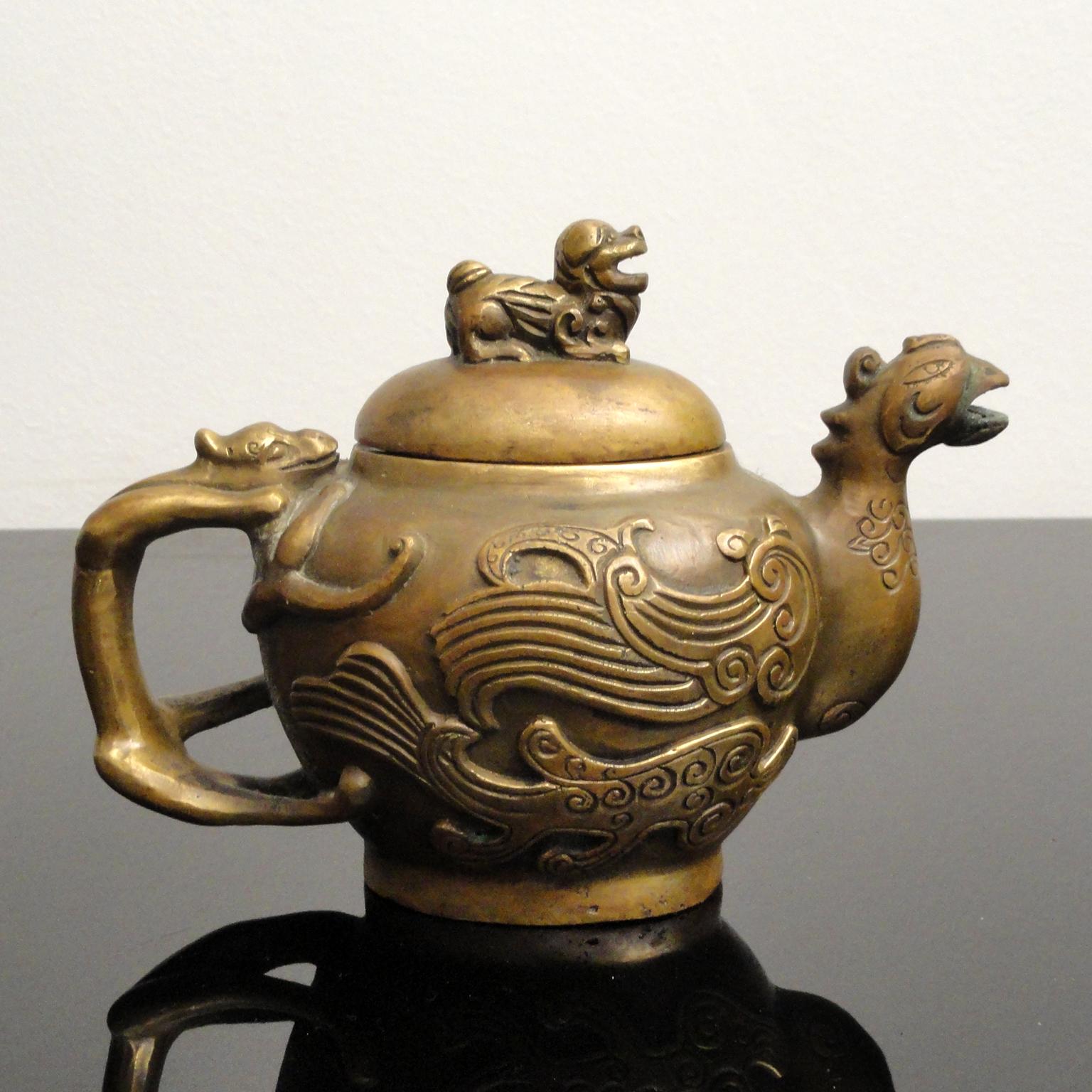 Jarra de bronce diseñada como un ave fénix,
China, finales del siglo XIX-principios del XX.
Marca apócrifa Xuande.
Medidas: Altura 12,5 cm.
Antigua Tetera de Bronce con Motivo Mítico - Exquisito Coleccionable Tallado a Mano
Eleva tu colección con