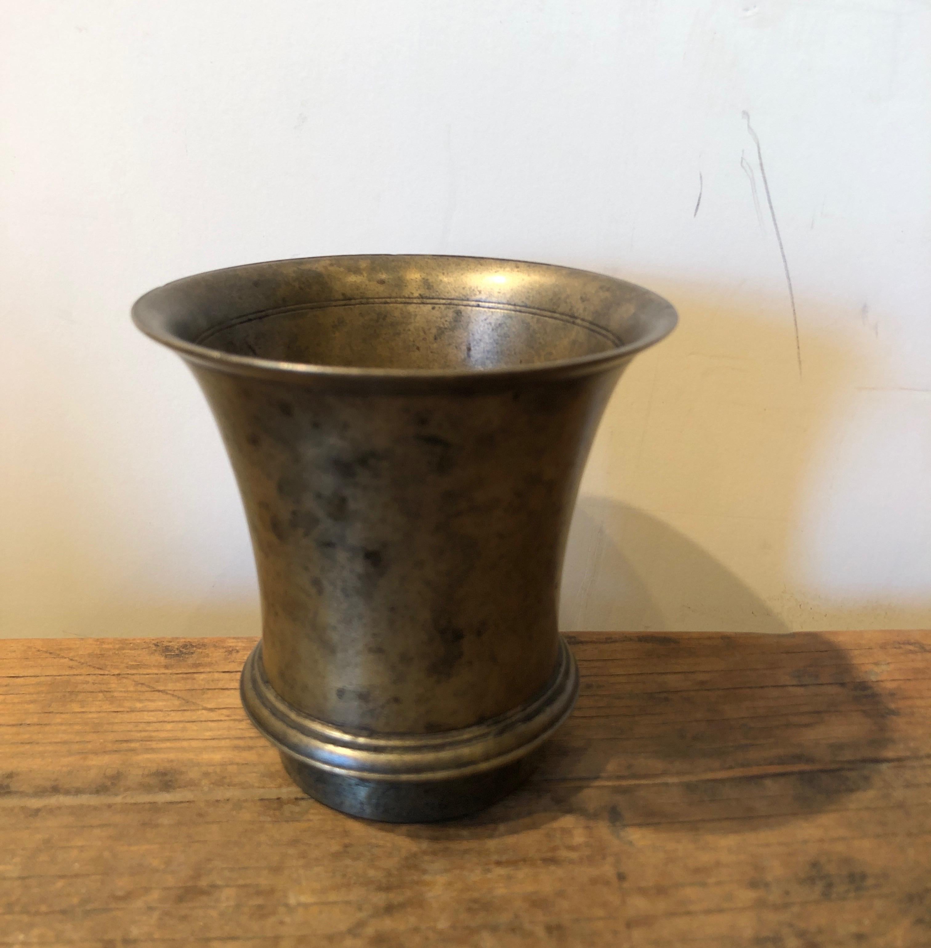 This beautifully cast, simple and highly detailed bronze holy water cup was used in Buddhist rituals in Tibet. The rich patina speaks of the many years of handling and use of this spiritual object.