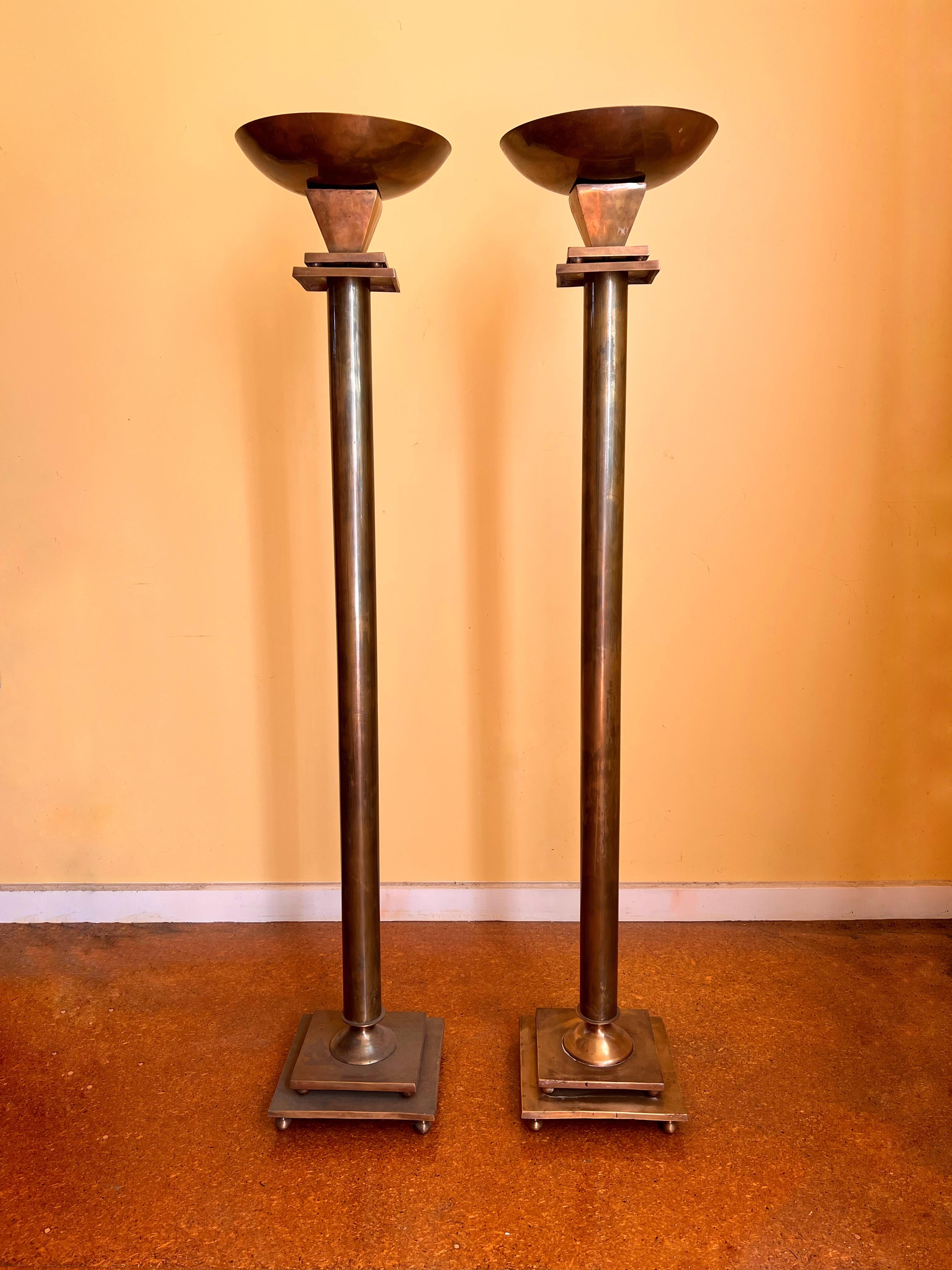 Tall Bronze Torchères. Arts and Crafts era with Art Deco feel. The bronze has aged with a beautiful patina. Square plates sit upon bronze balls. Beautiful shape and sculptural art. Inside the top torch is a spike to place a candle.

1200cm high