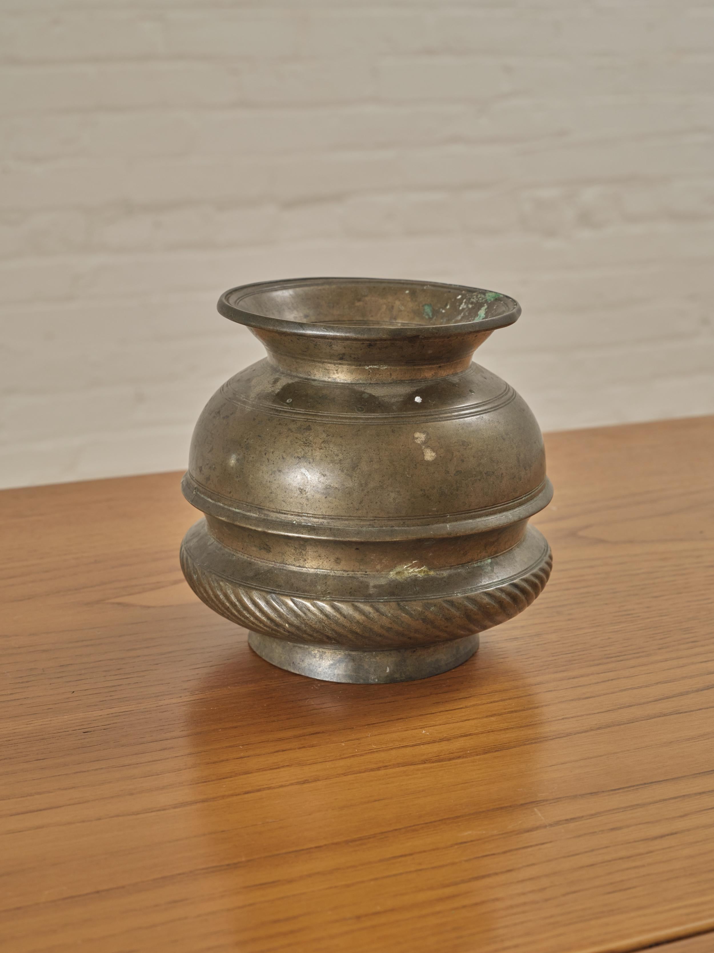 Antique Bronze Vase, also recognized as a drinking pot with intricate engravings.


