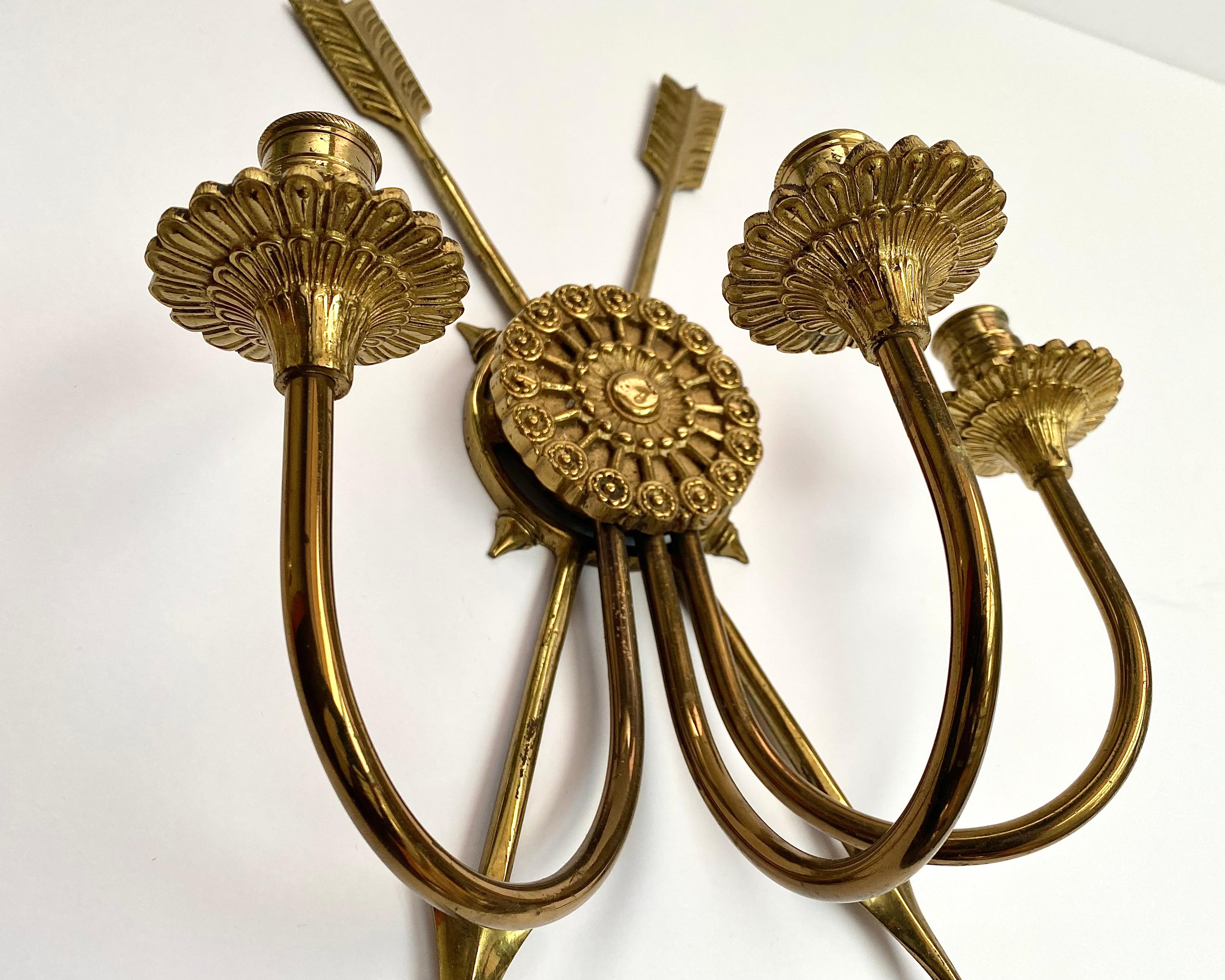 Elegant French Empire style two-arm gilt bronze sconce with two arrows on body and round backplate, early 20th Century.

The candelabra will become the highlight of your interior; they will add an atmosphere of romance and mystery.

Luxurious