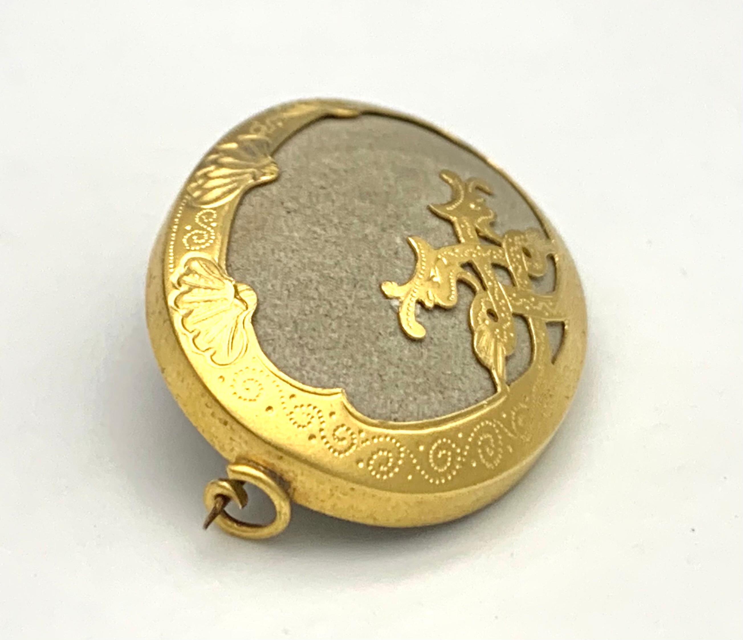 This highly unusual piece of jewellery in the shape of a gold mounted pebble was made in the mid 19th century. The gold decoration in the shape of two snakes entwined to form an infinity symbol is quite out of the ordinary. Maybe the brooch was made
