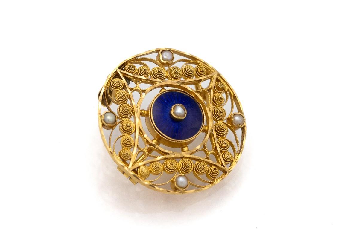 Antique brooch with a pendant function made of 0.750 yellow gold; centrally decorated with blue enamel and four natural oriental pearls.

In the form of a brooch it will be a beautiful timeless addition to a shirt or jacket, and in the form of a