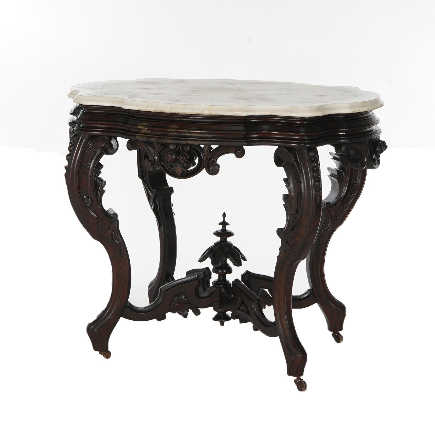 ***Ask About Reduced In-House Delivery Rates - Reliable Professional Service & Fully Insured***

An antique Brooks parlor table offers shaped and beveled marble turtle top over heavily carved walnut base having foliate, floral and scroll elements