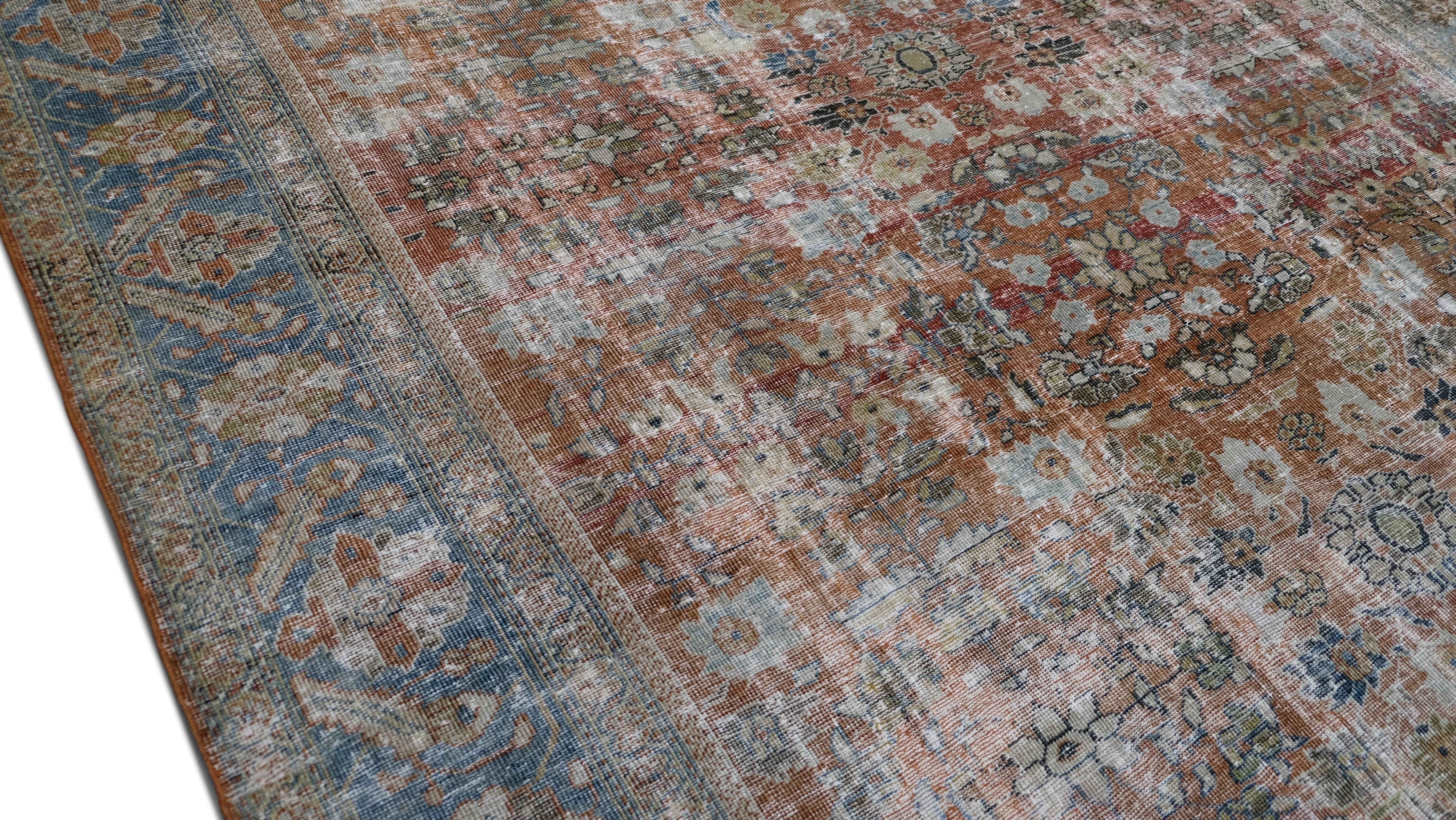 Ce tapis antique en laine nouée à la main est un chef-d'œuvre de l'artisanat traditionnel. Il présente un superbe motif Mahal en relief. Le motif complexe est tissé avec  bleu sourd et marron, créant une patine magnifiquement vieillie qui exsude le