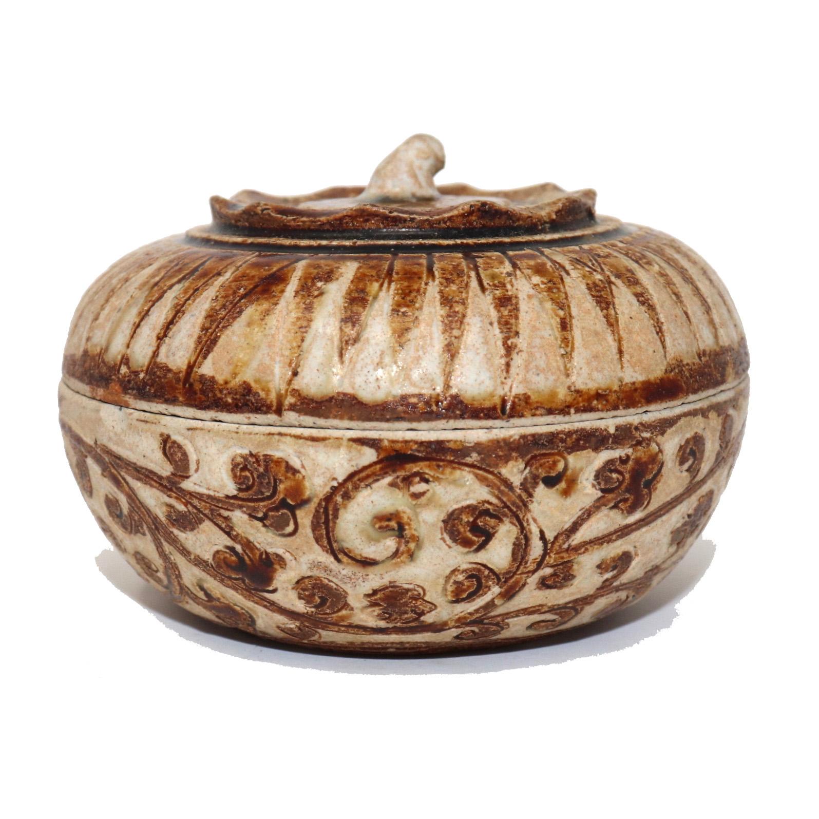 Antique ceramic covered box from the Sawankhalok kilns, Thailand of squat globular persimmon form with pinched sepal ridge and curled stem finial top decorated in a caramel brown and translucent white glaze on the stoneware biscuit in a saw tooth