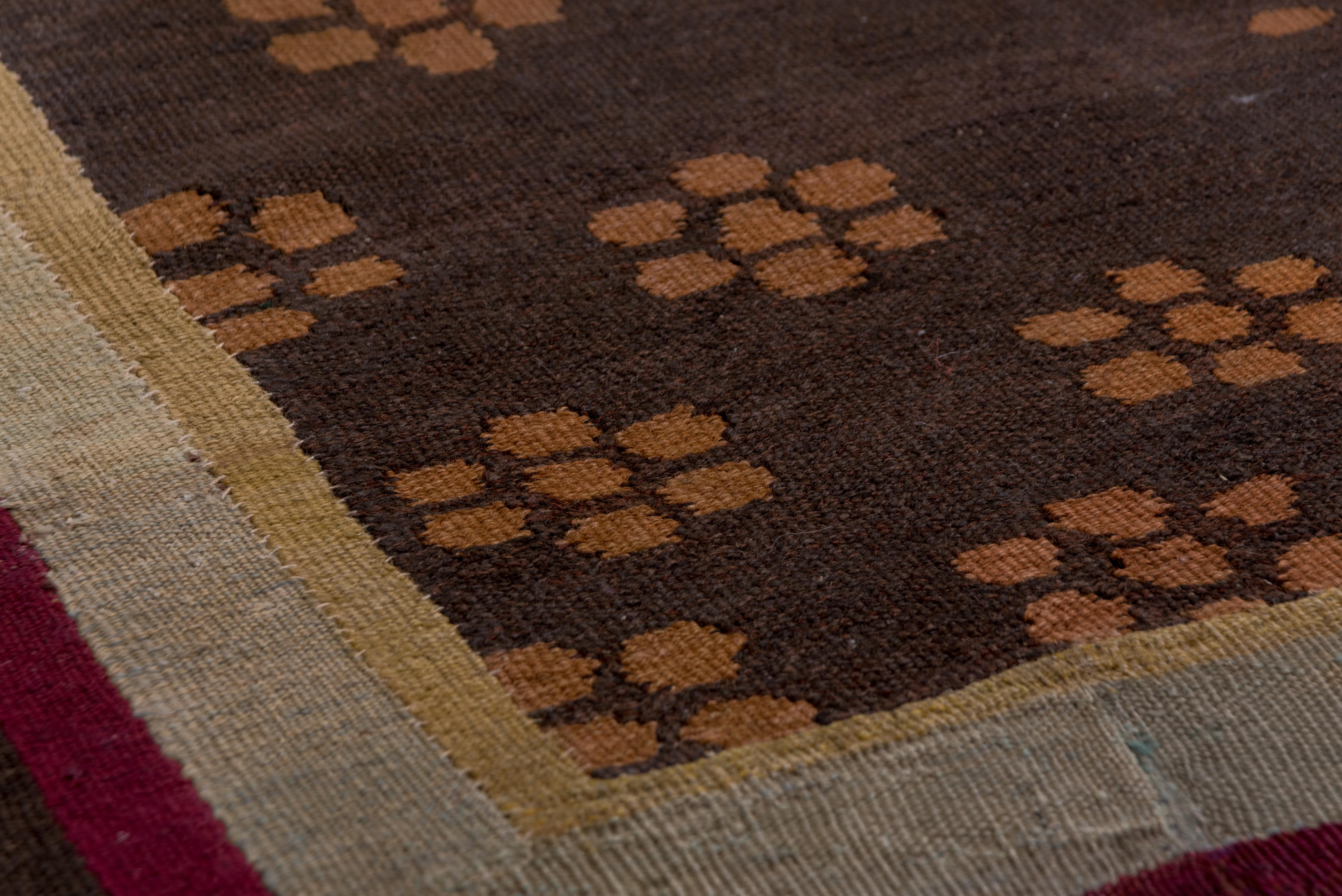 A leaf and flower wreath surrounds the nested circular medallion in beige and straw, on the brownfield loosely covered by an all-over small rosette pattern. Plain ecru and brown borders. Charles X style, but later in the 19th century.