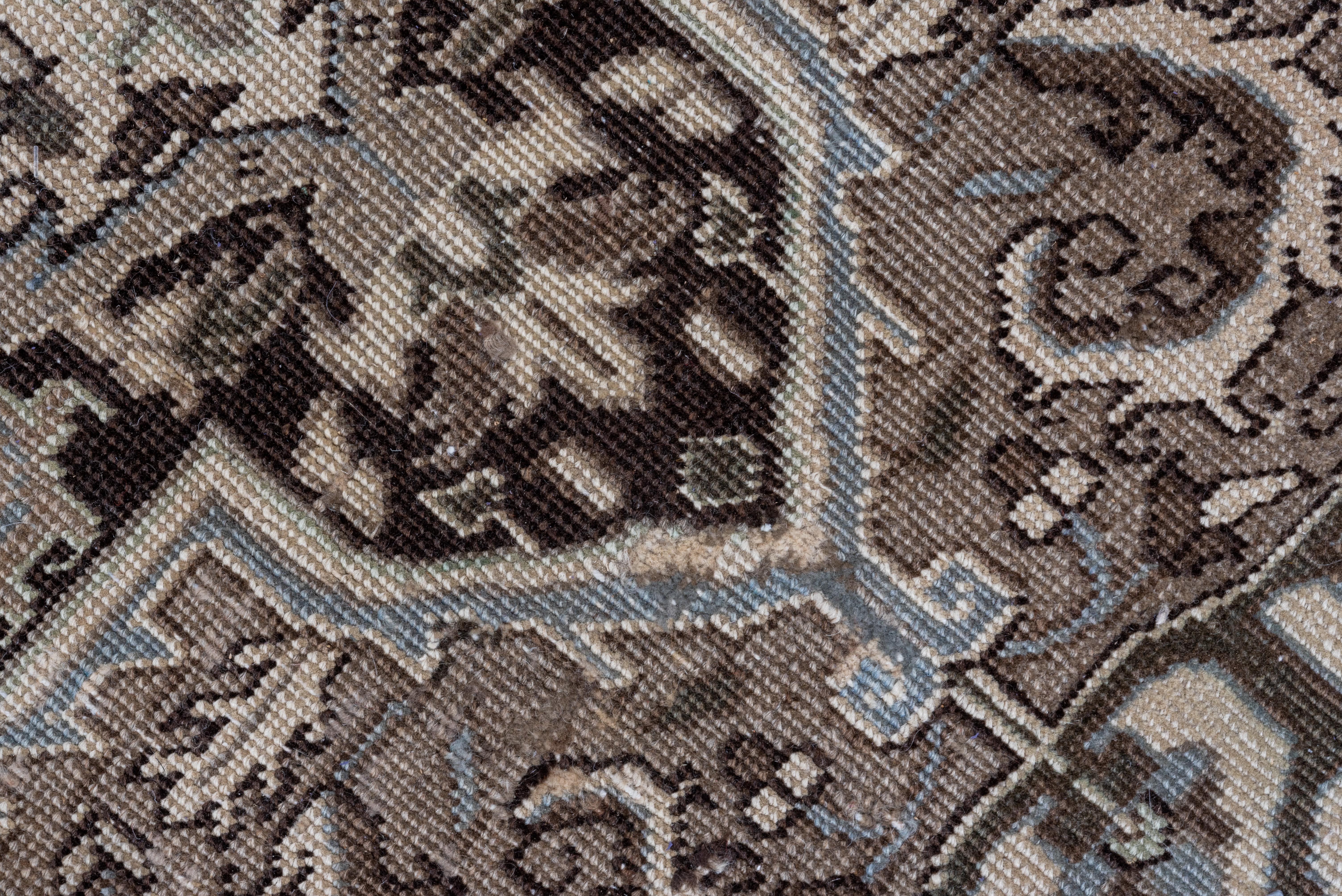 This NW Persian, moderate weave rustic medallion carpets has a soft brown ground centered by a dramatic near black scalloped and pointed motif with a cru concave octogramme Sub-medallion. Volute leaves in the field. Ecru corners. Near black