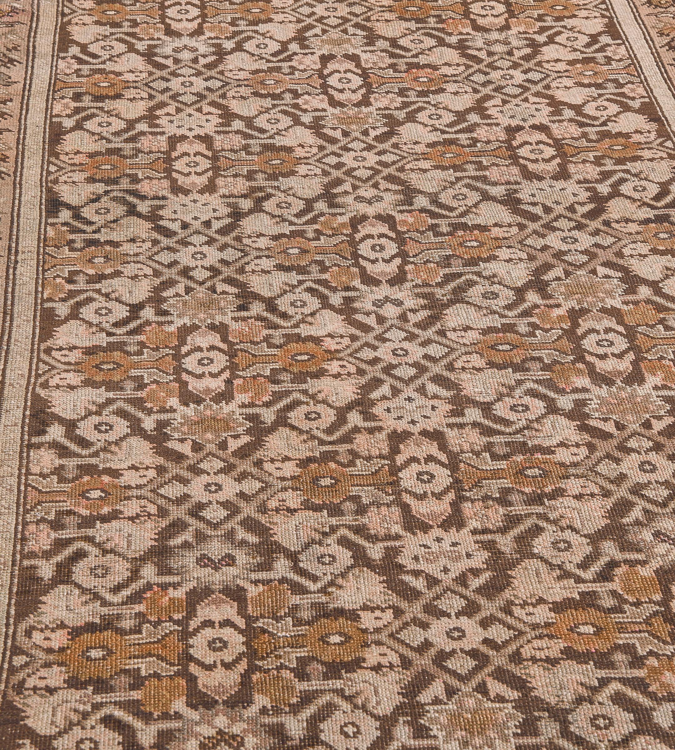 This antique Karabagh runner has a chocolate-brown field with a mole-brown, buff-brown and fox-brown overall angular herati-pattern, in a pale terracotta-pink border with chocolate-brown, mole-brown and buff-brown spaced flowering plants and leaf