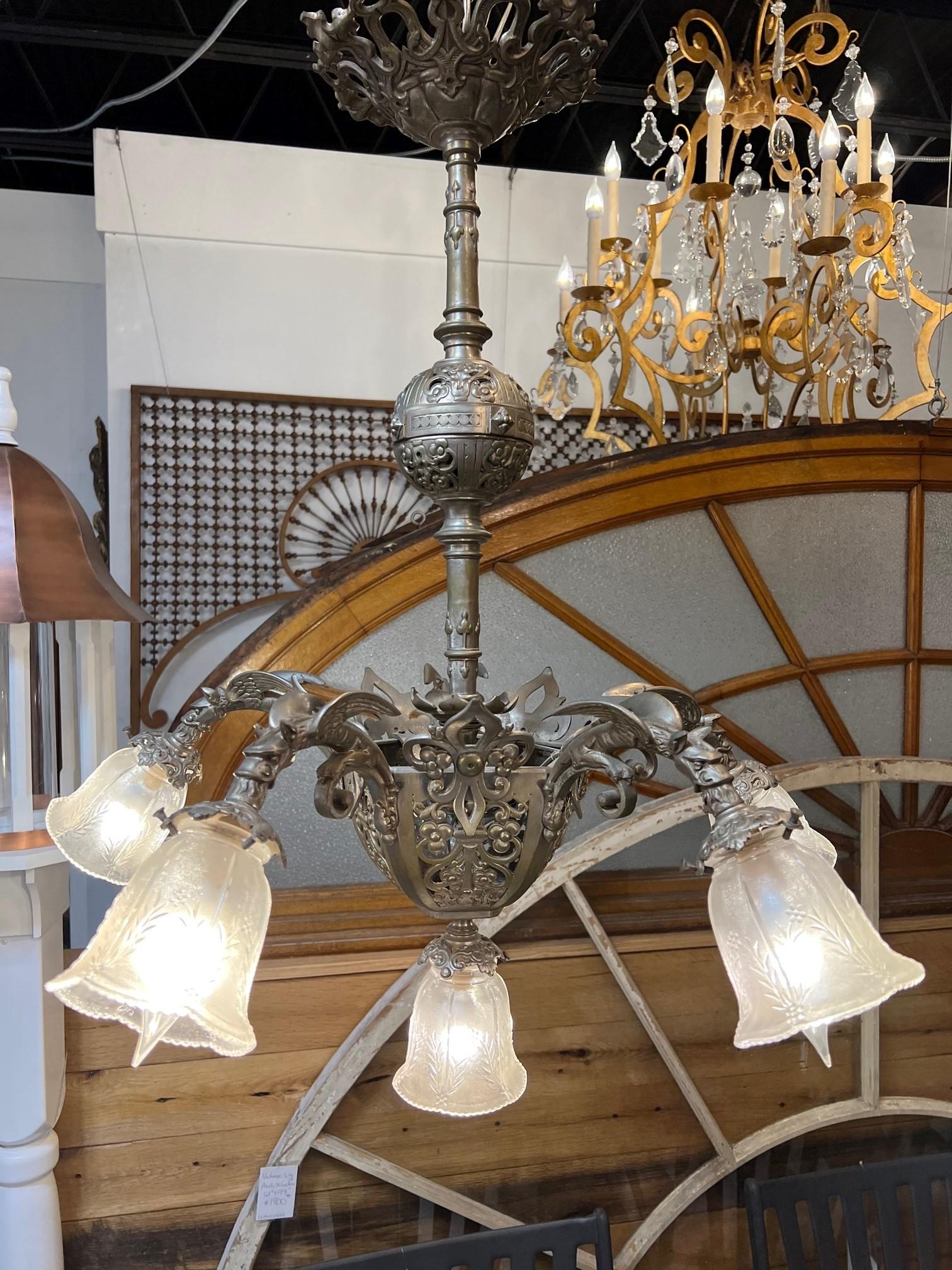 Beautiful antique brush nickel brass chandelier with five griffin arms and a center light. Its a very decorative chandelier with intricate detailing with five unique griffin lights. I believe its from the Early to Mid-20th century and was