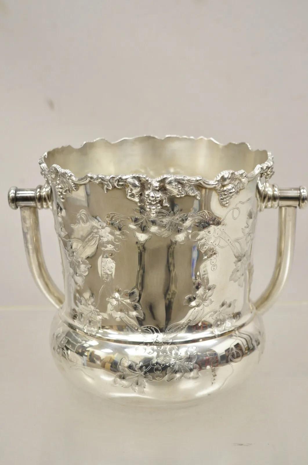 Antique BSCEP Anglais Victorien Plaqué Argent  Seau à glace Grapevine avec poignée. L'objet présente une poignée réticulée, des repoussés de vignes et de couronnes sur l'ensemble de la pièce, une forme bulbeuse et galbée, un poinçon d'origine, un