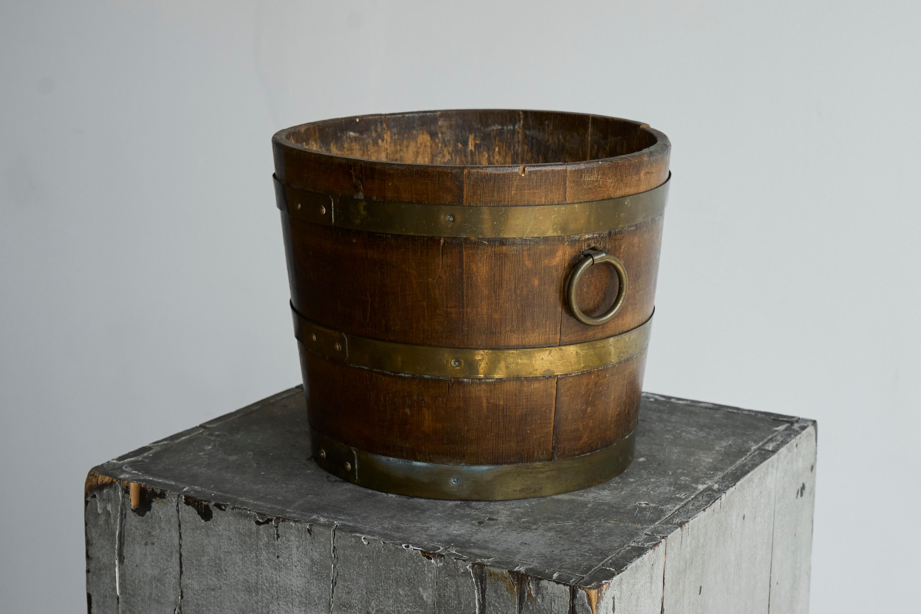 Antique Bucket in Wood and Brass 19th Century.

Wonderful antique bucket in wood and brass. Very nice patina on the brass. Great barrel design with decorative ears. Would be great as a waste paper bin, a decorative log basket or as a vase for some